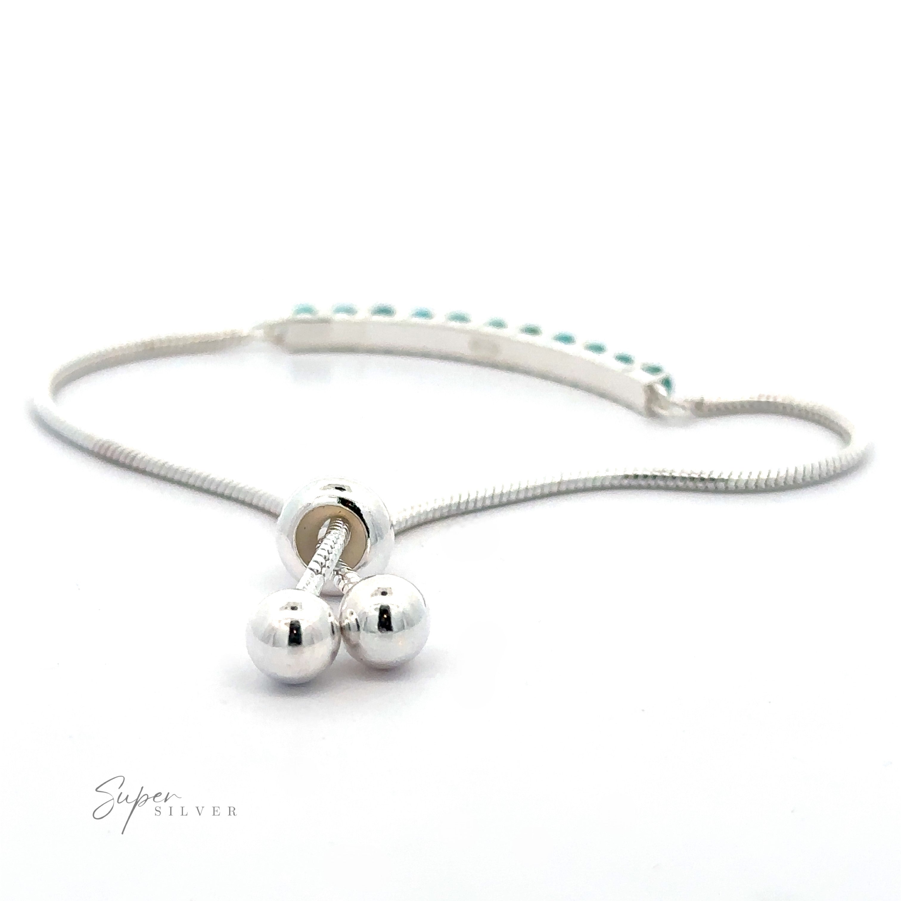 A Silver Adjustable Bracelet with American Turquoise, featuring a delicate silver curved bar bracelet with two spherical charms and a rectangular bar studded with American turquoise. The adjustable snake chain ensures a perfect fit against the plain white background.