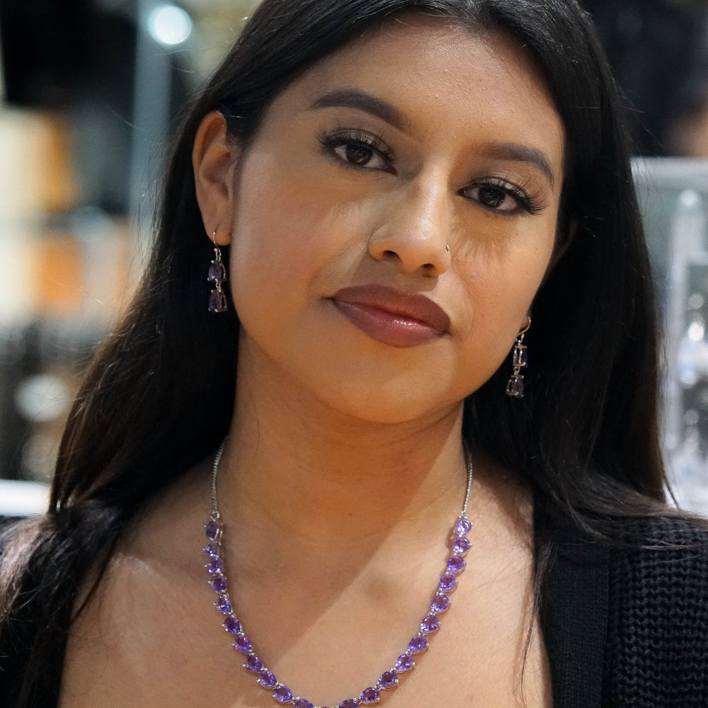 
                  
                    A woman with long dark hair wearing an Elegant Faceted Gemstone Jewelry Set in sterling silver, looking directly at the camera.
                  
                