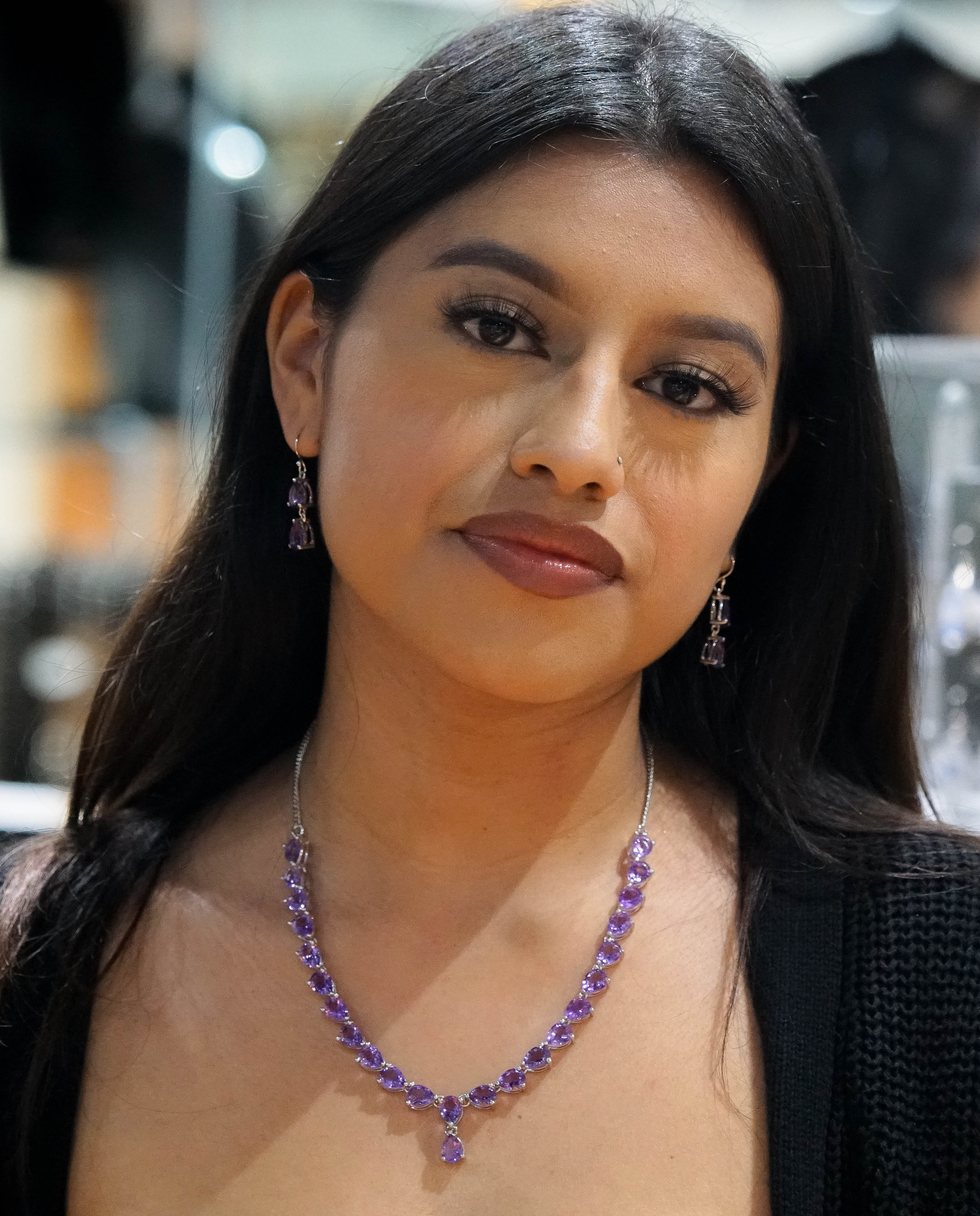 A woman with long dark hair wearing an Elegant Faceted Gemstone Jewelry Set in sterling silver, looking directly at the camera.