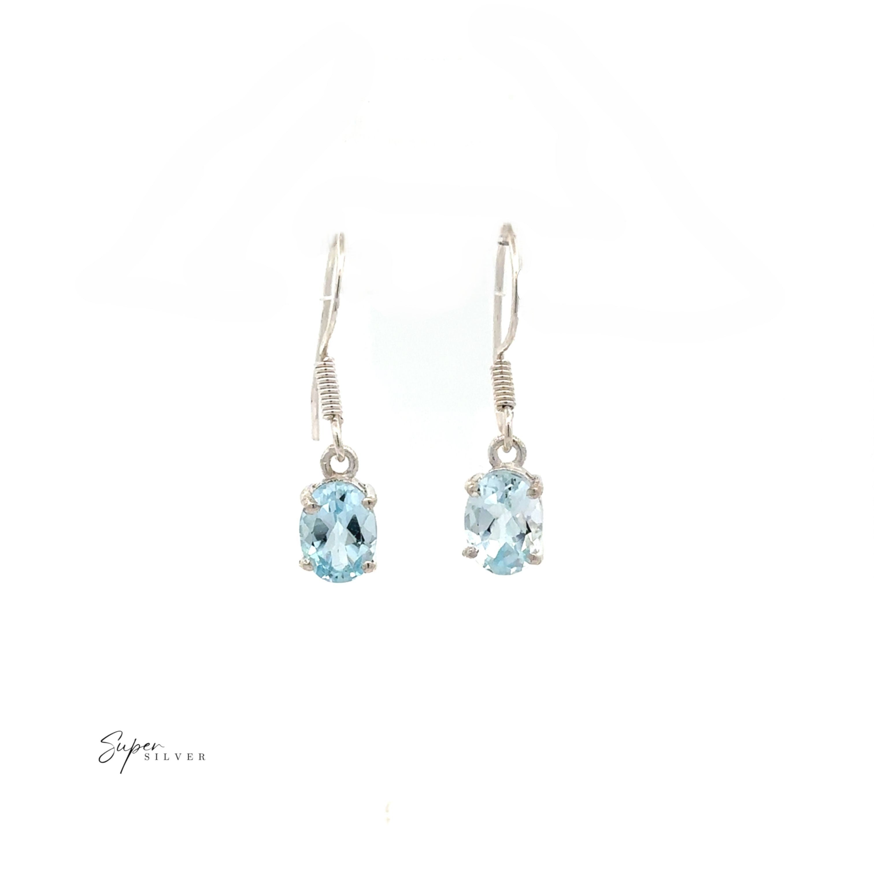 Brilliant Oval Gemstone Earrings—sterling silver prong-set with oval light blue stones, elegantly shown on a white background.