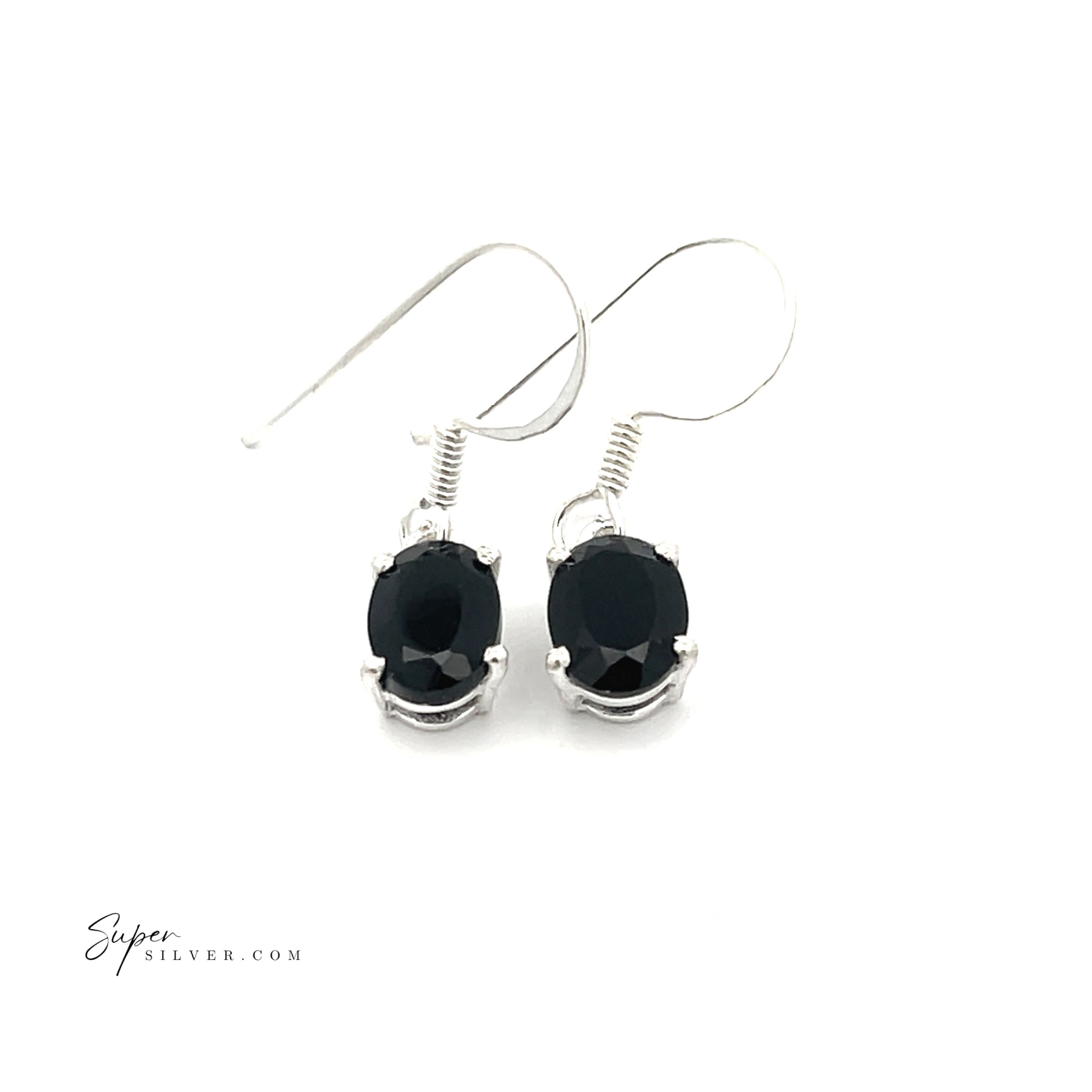 Brilliant Oval Gemstone Earrings in sterling silver feature elegantly prong-set, oval-shaped black stones, displayed on a white background.