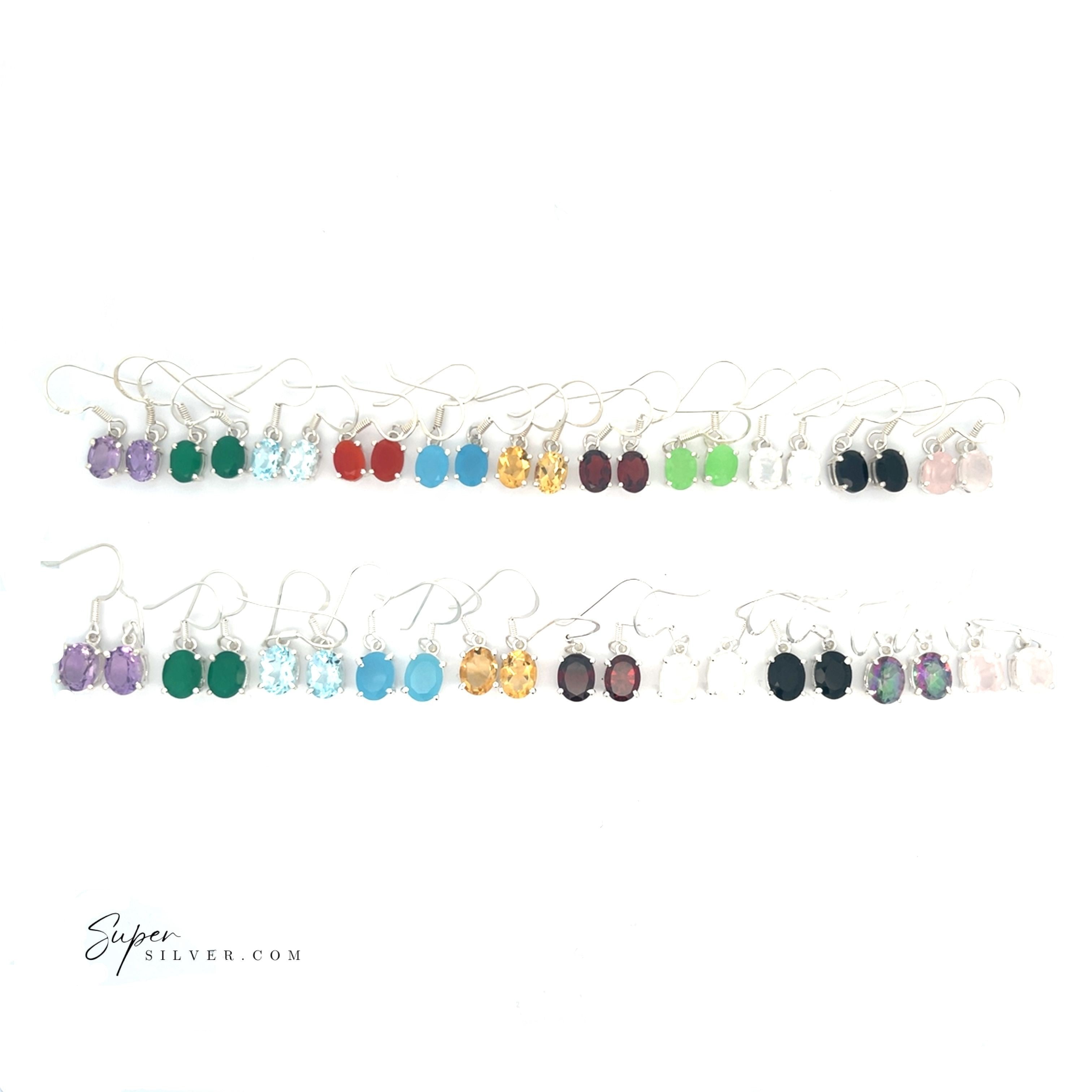 A set of Brilliant Oval Gemstone Earrings displayed in two rows on a white background, each pair prong-set and showcasing a unique vibrant gemstone color.