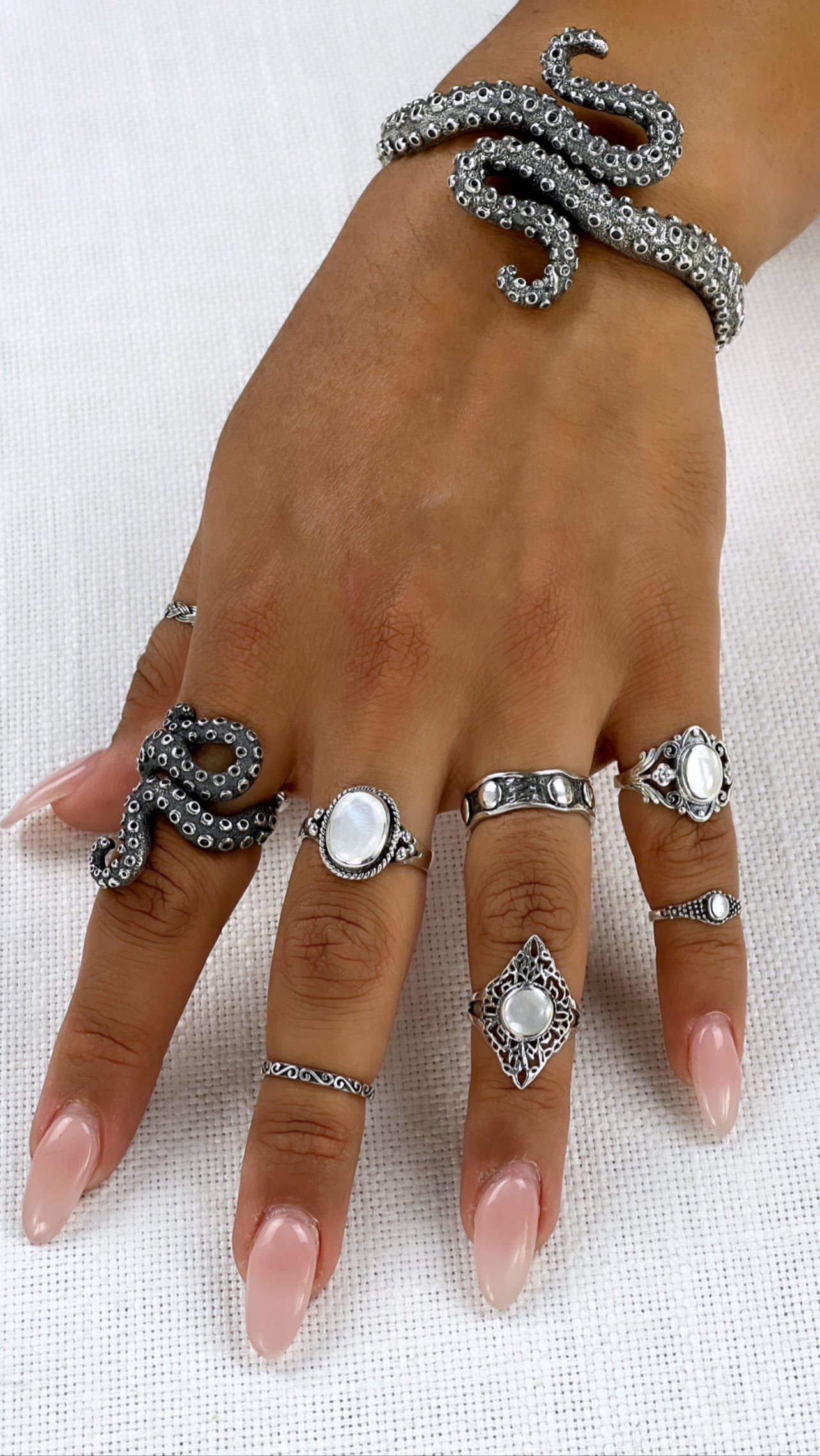 A woman's hand adorned with a mesmerizing Statement Octopus Tentacle Ring, subtly capturing the deep sea's enigmatic allure.