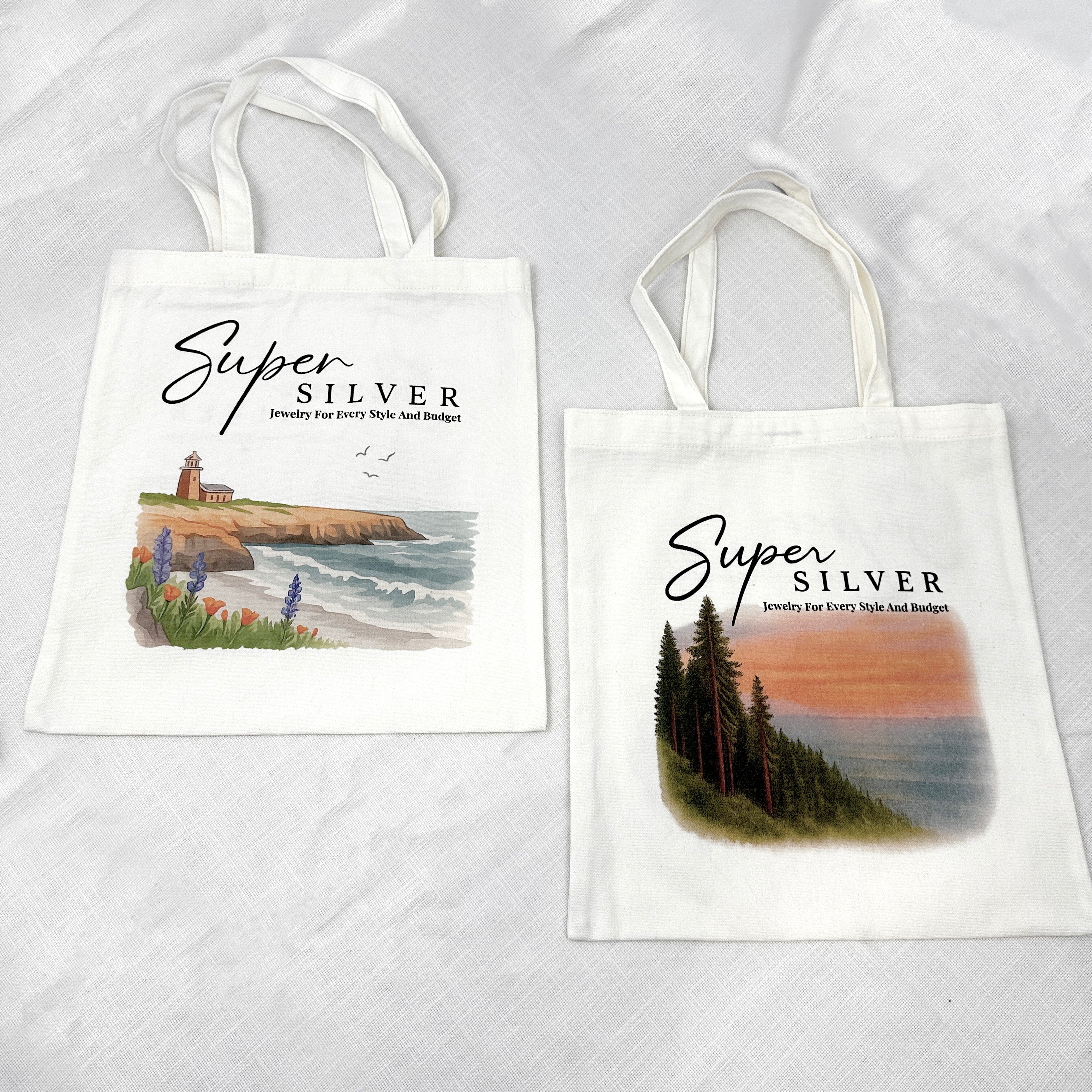 The Super Silver Canvas Tote Bag comes in two white designs: one with a seaside lighthouse and one with redwoods at sunset—stylish Santa Cruz totes for daily adventures.