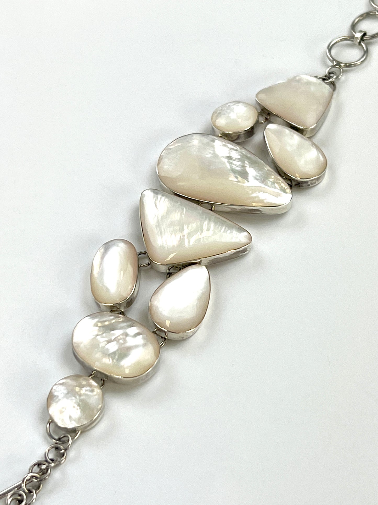A luminous Statement Mother of Pearl Bracelet by Super Silver on a white surface.