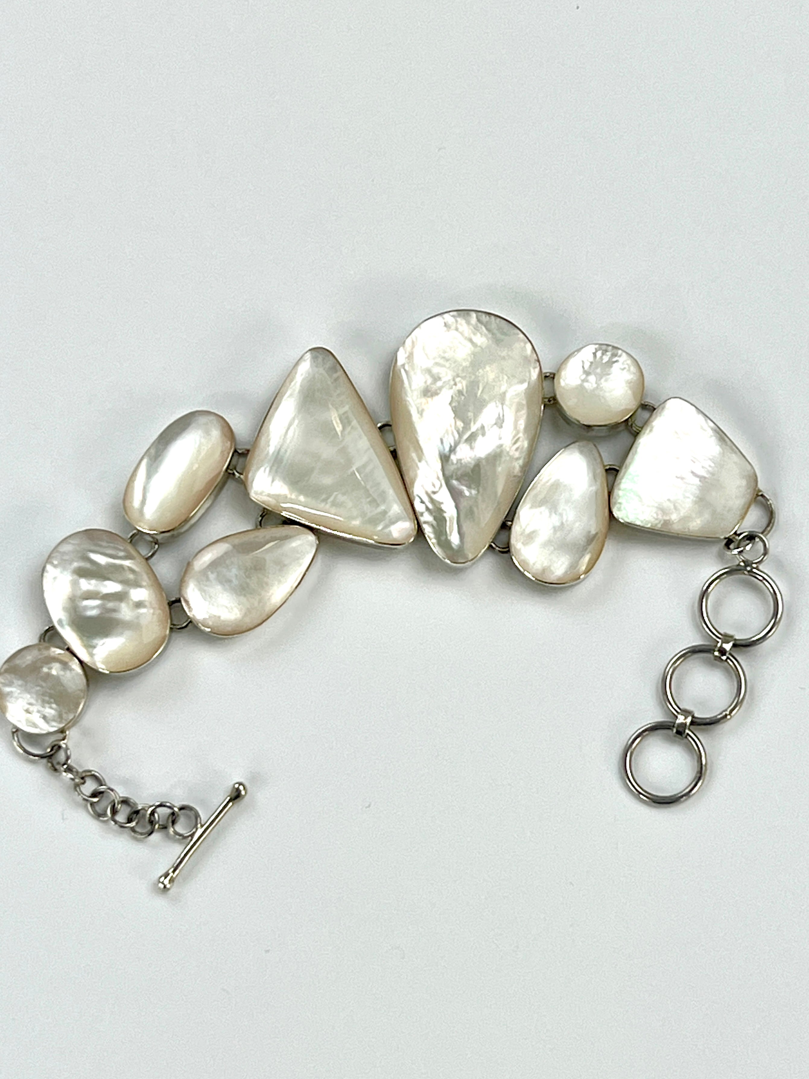 A Super Silver Statement Mother of Pearl Bracelet on a white surface.