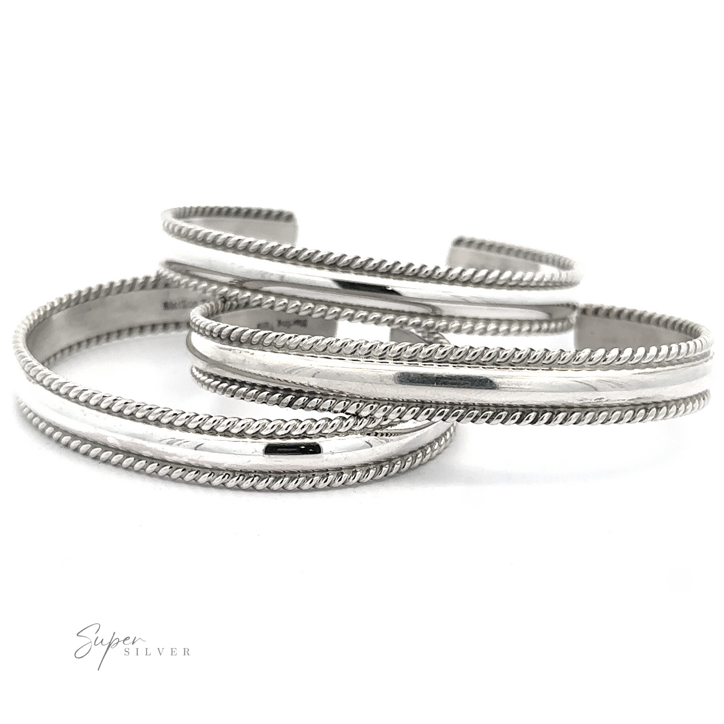 Three polished Native American Handmade Silver Rope Cuffs with rope-like edges, overlapping each other on a white background. The logo "Super Silver" is in the bottom left corner, showcasing these stunning statement pieces.
