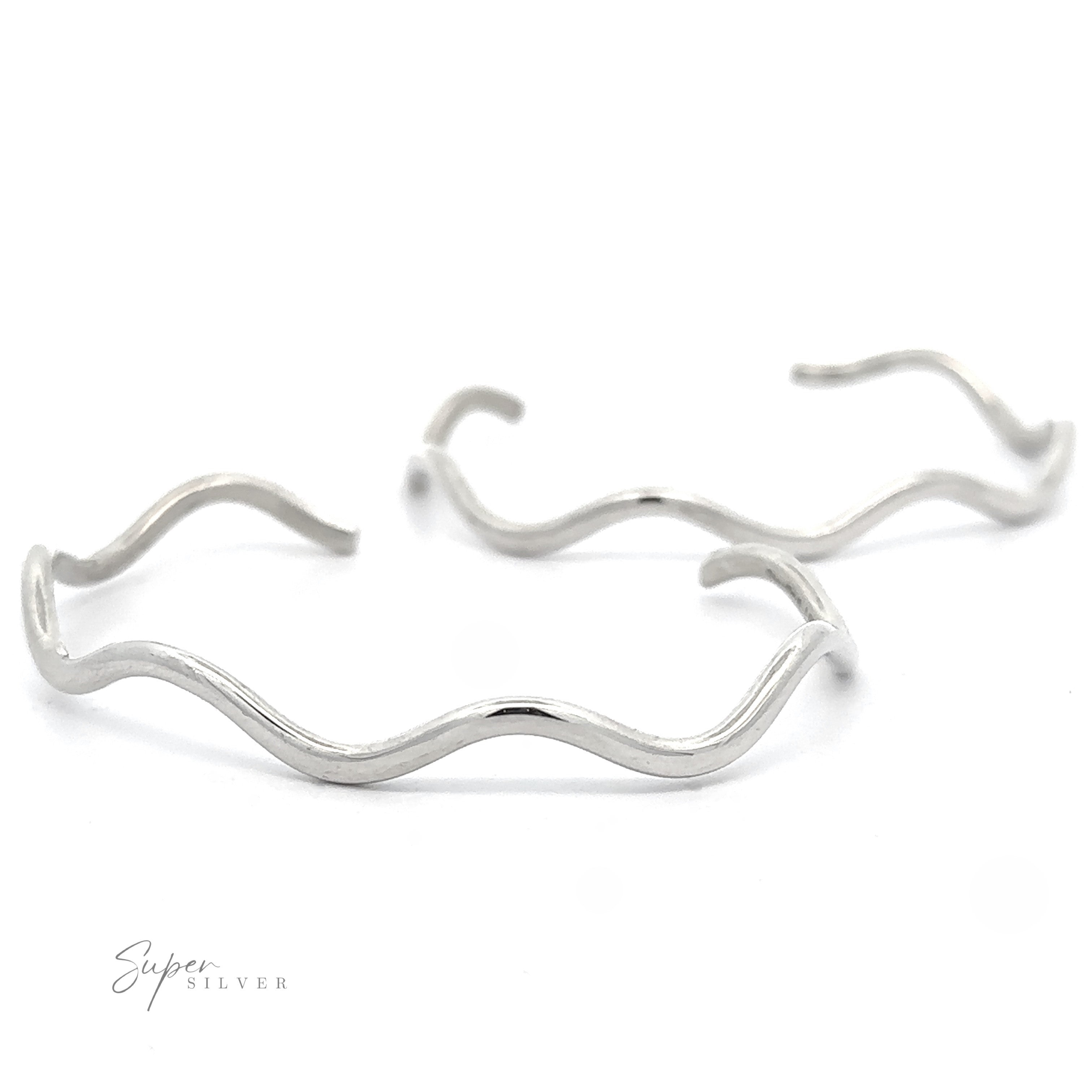Two Native American Handmade Silver Wavy Cuff bracelets laid out against a white background. The phrase "Super Silver" is seen in the bottom left corner, capturing the elegance of fine jewelry.