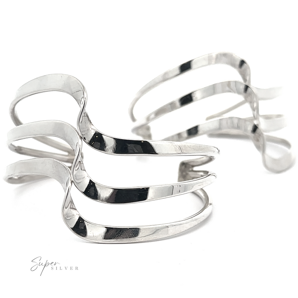 Two sculptural, silver-colored rings with intertwining bands are displayed against a white background. Designed by Super Silver, these elegant pieces evoke the artistry of the Native American Handmade Silver Triple Wave Cuff.