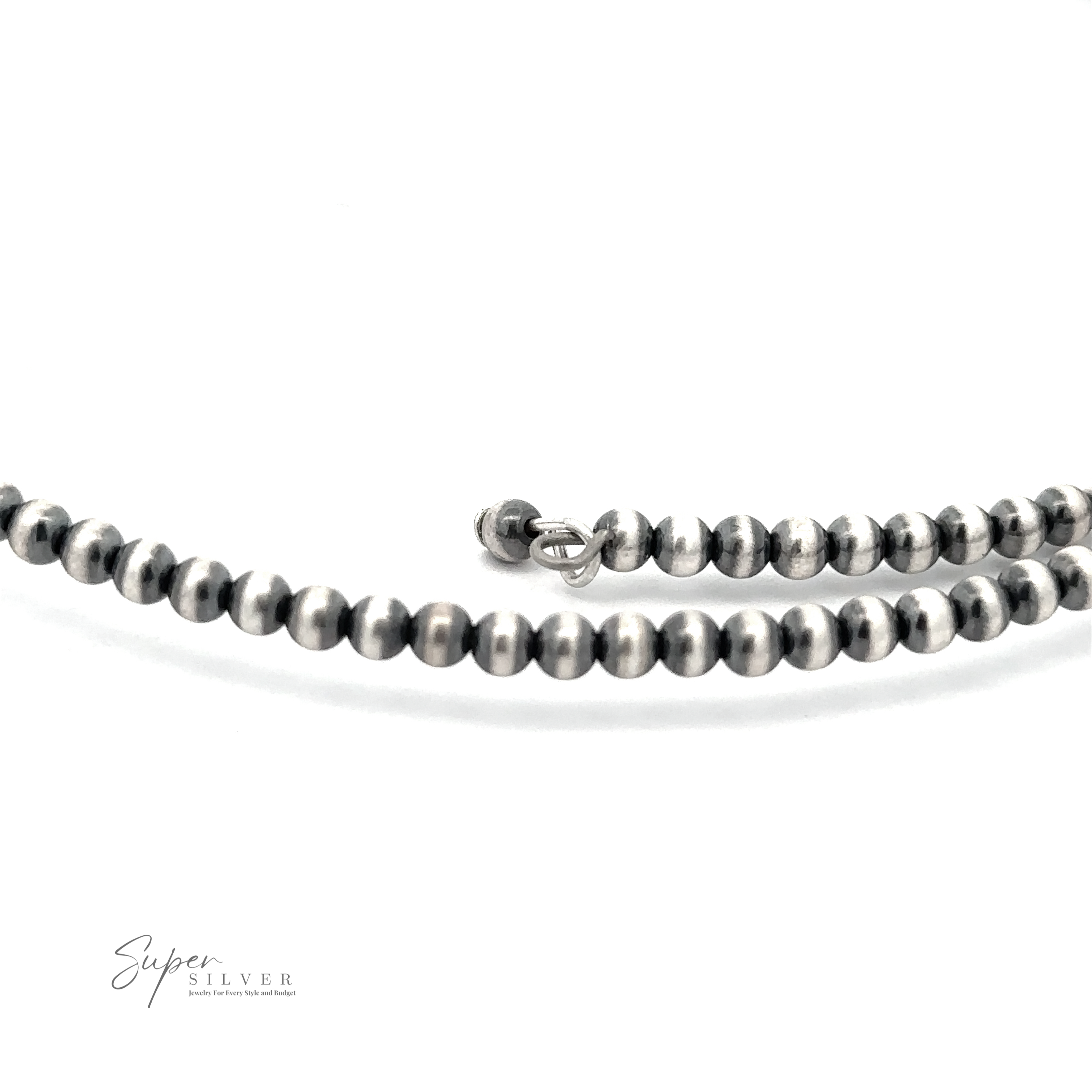 Close-up of a beaded silver necklace with a clasp, arranged on a white background. A small "Wrap Around Spiny Oyster Shell Choker Necklace" logo is visible in the bottom left corner, reminiscent of the intricate work by Native American artisans.