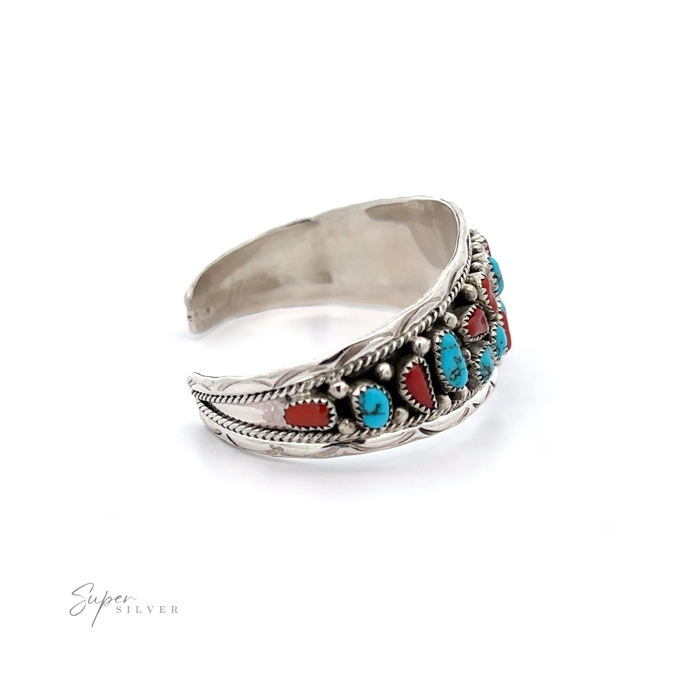 Native American Cluster Turquoise Cuff Bracelet featuring a feather design with inlaid turquoise and coral stones, embodying Southwest charm, on a white background.