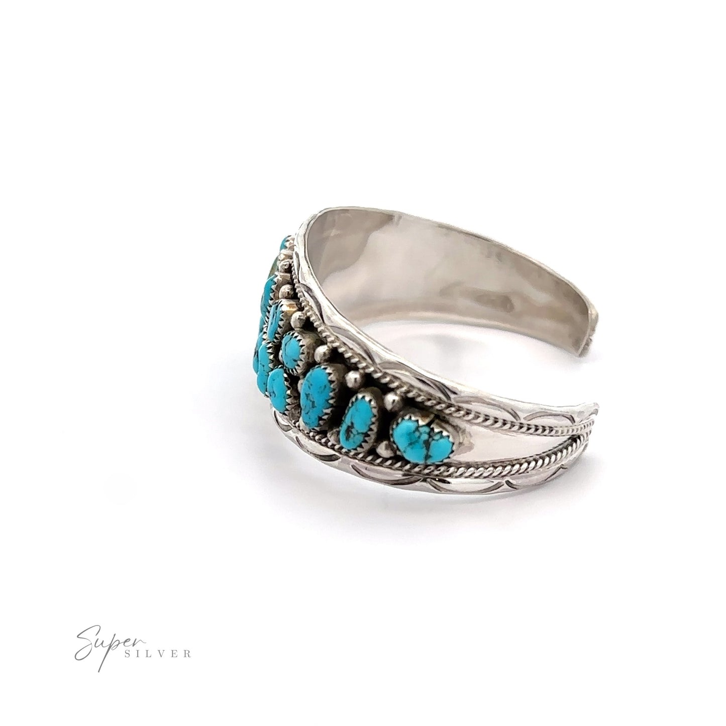 
                  
                    A Native American Cluster Turquoise Cuff Bracelet adorned with detailed metalwork on a white background, reflecting the Native American jewelry style.
                  
                