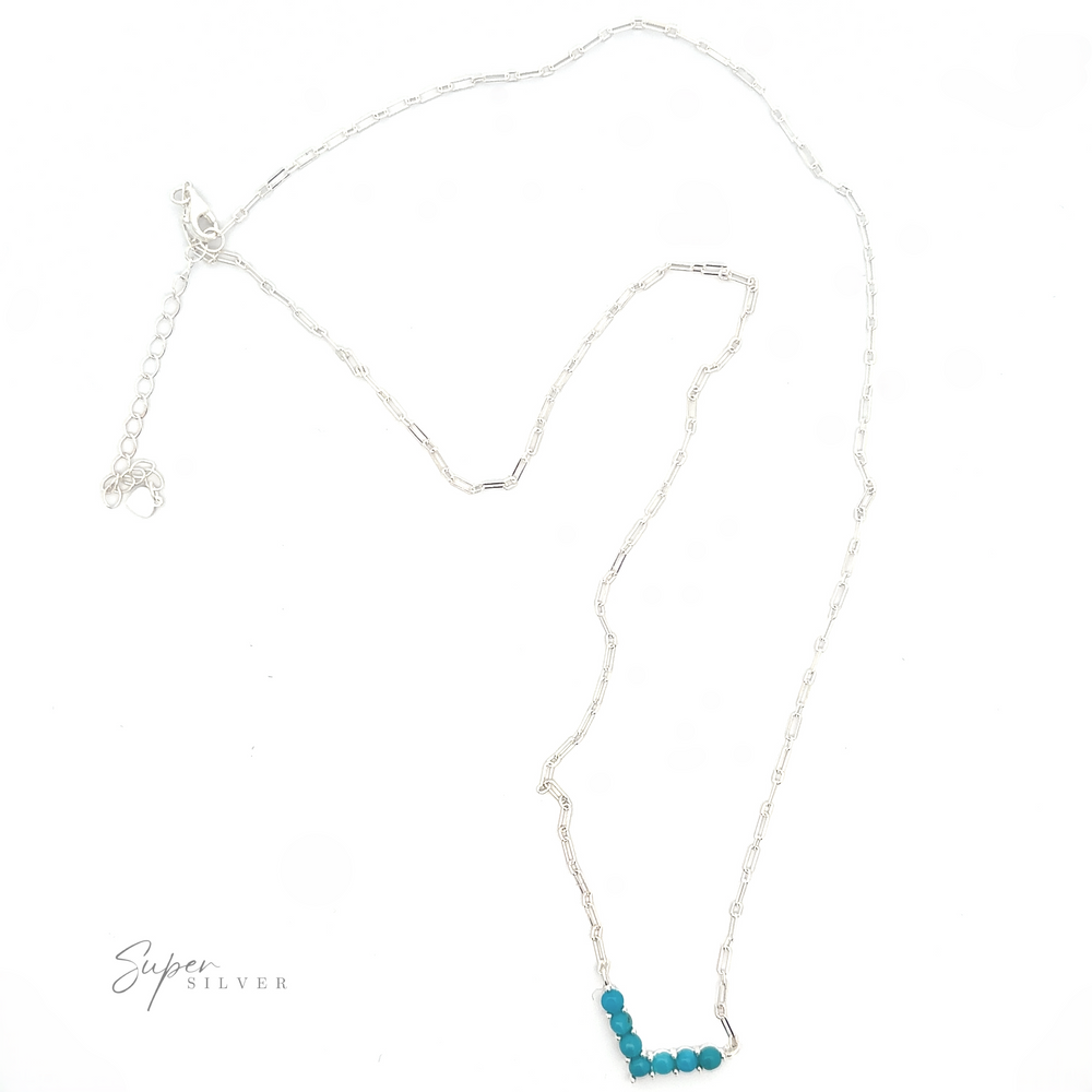 
                  
                    A silver, adjustable Dainty V-Shaped American Turquoise Necklace with a delicate chain and a small cluster of turquoise beads, displayed on a white background.
                  
                