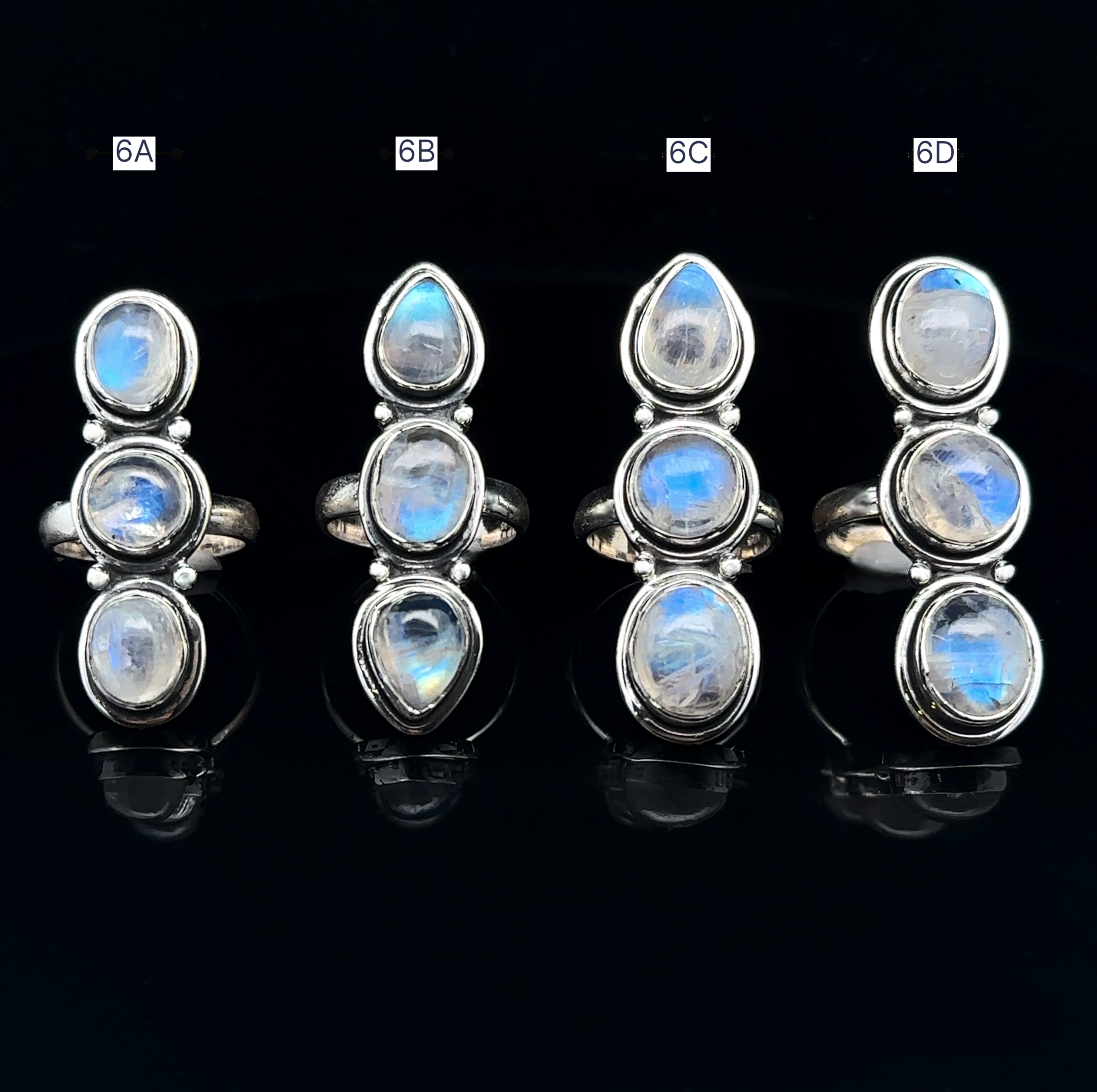 Four Triple Moonstone Rings crafted in sterling silver, exuding goddess energy, are labeled 6A, 6B, 6C, and 6D on a black background.
