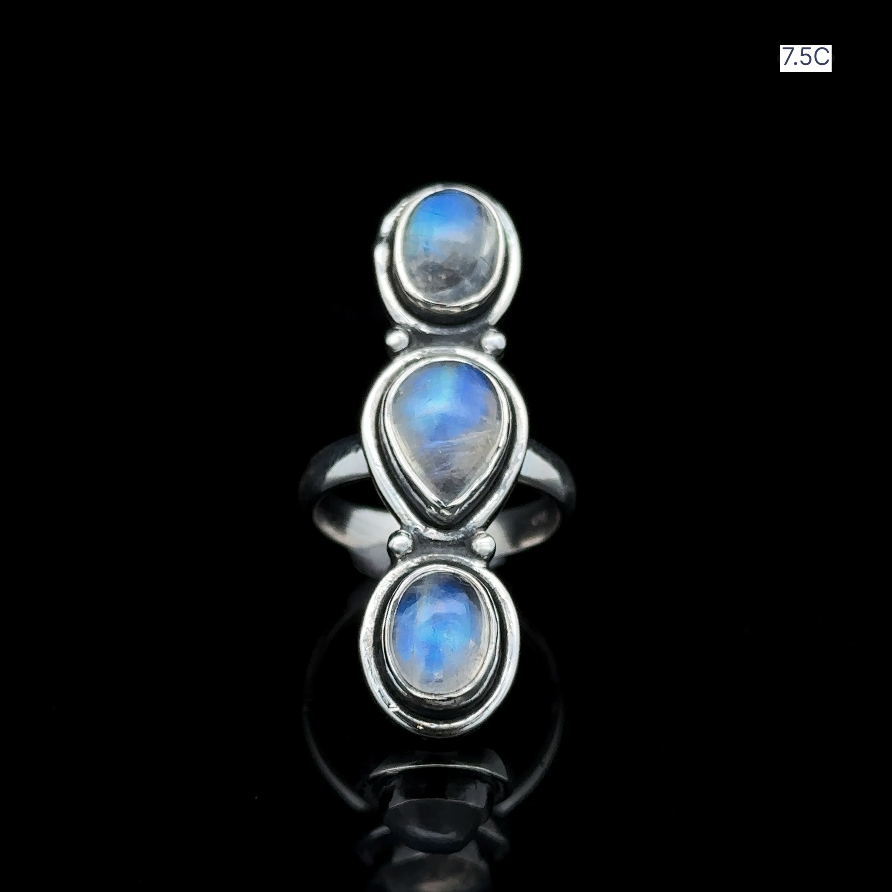 Triple Moonstone Ring crafted from sterling silver, featuring three moonstone gems arranged vertically against a dark setting, radiating goddess energy. Size 7.5C.