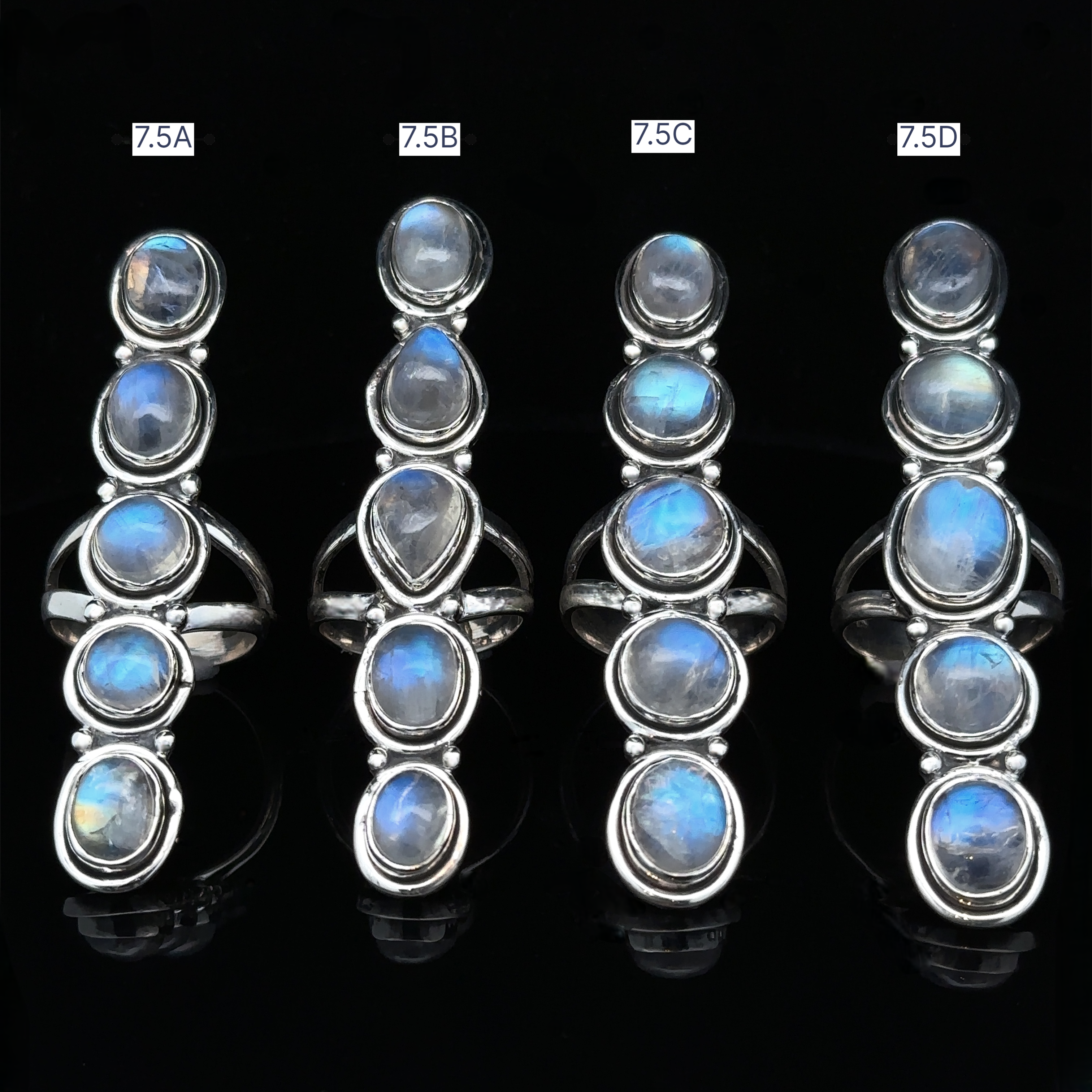 Four Moonstone Ladder Rings, crafted in sterling silver with oval and teardrop blue moonstones, are displayed vertically on a black background and labeled 7.5A, 7.5B, 7.5C, and 7.5D.