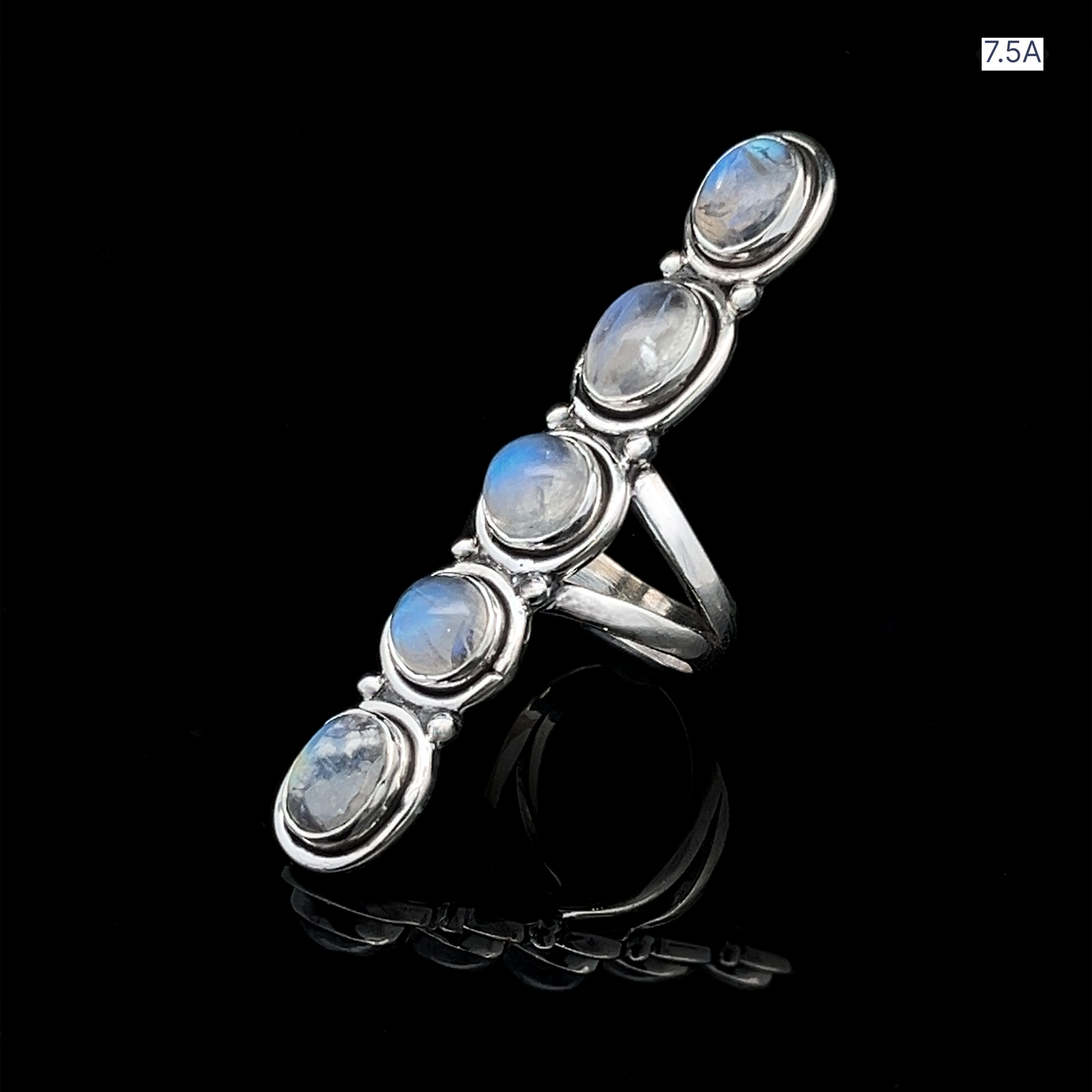 The Moonstone Ladder Ring is a long Bohemian-style sterling silver ring featuring five oval moonstone cabochons set vertically, shown on a black reflective surface.