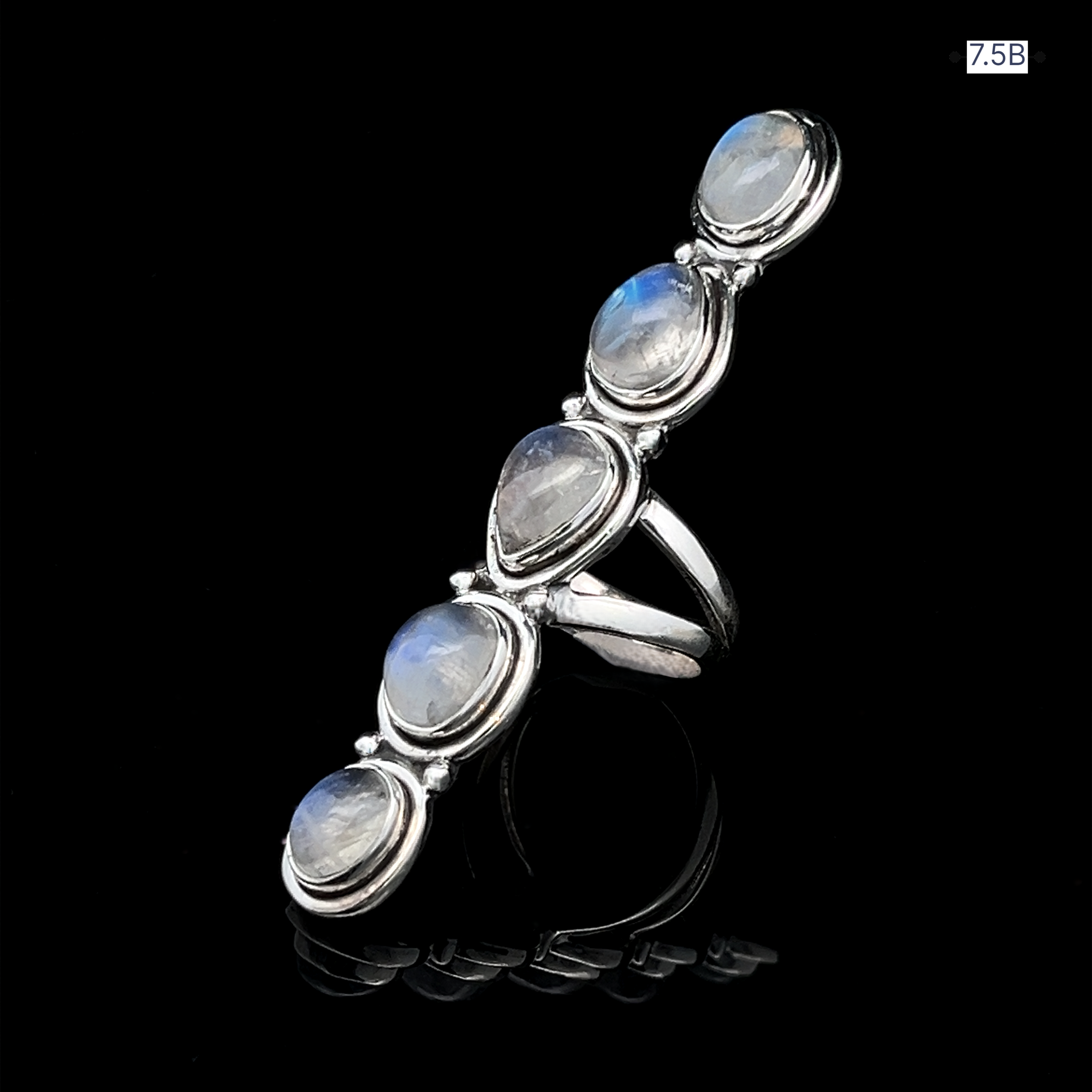 The Moonstone Ladder Ring, crafted in sterling silver, showcases five oval iridescent moonstone gems set vertically, displayed on a black reflective surface.