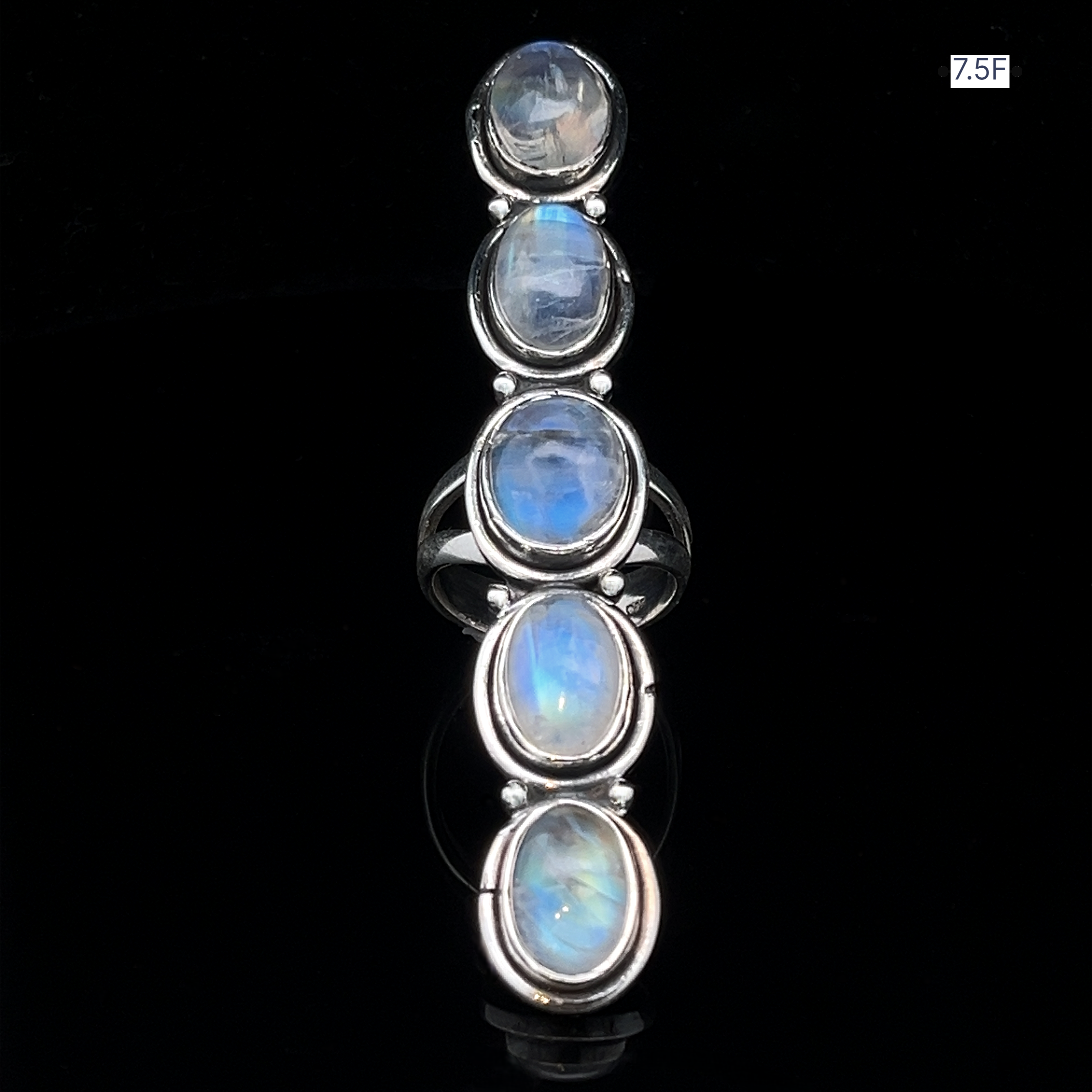 The Moonstone Ladder Ring is a bohemian sterling silver ring with five vertically arranged oval moonstone cabochons, set against a black background.