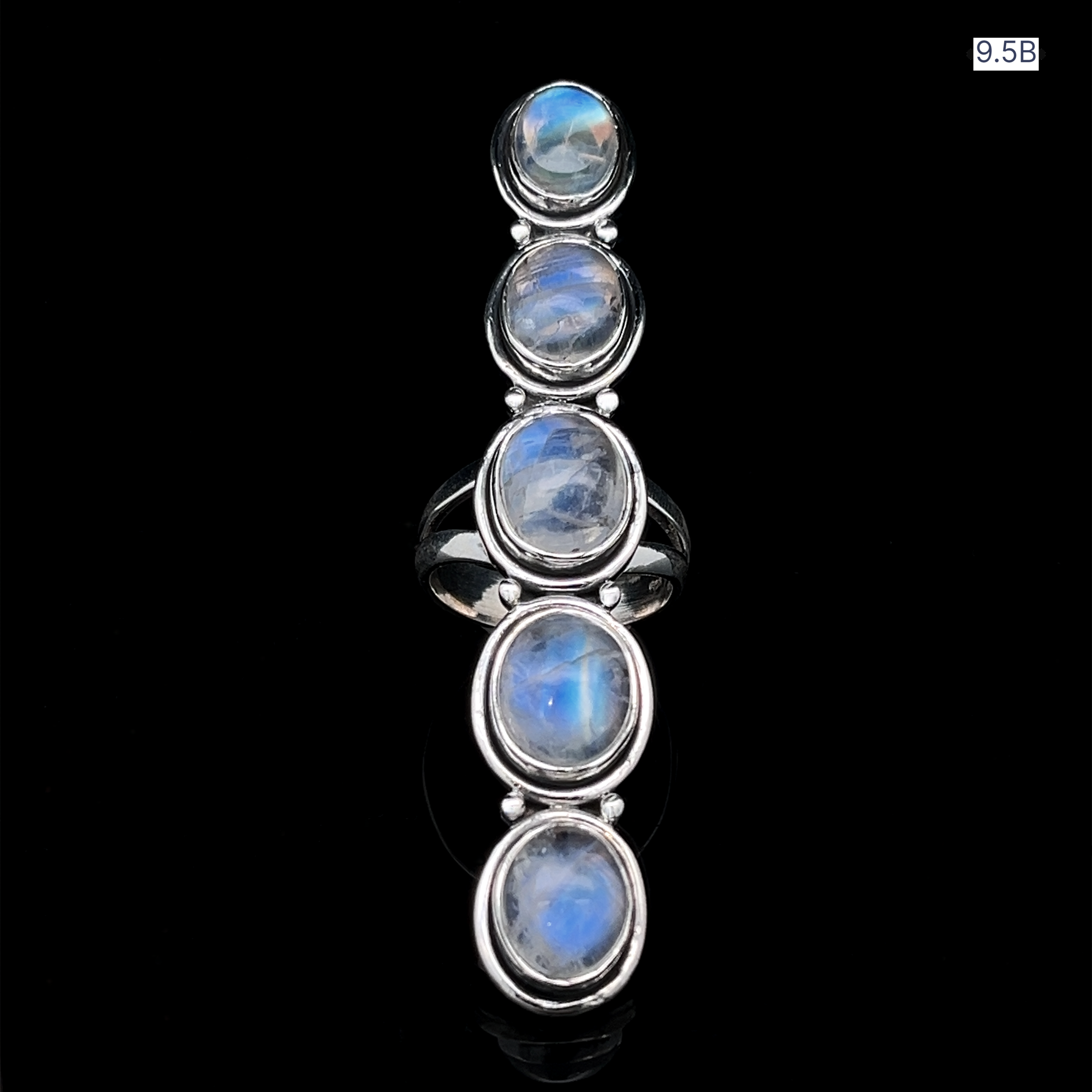 The Moonstone Ladder Ring features five oval moonstone cabochons set vertically in sterling silver, highlighted against a bold black backdrop.