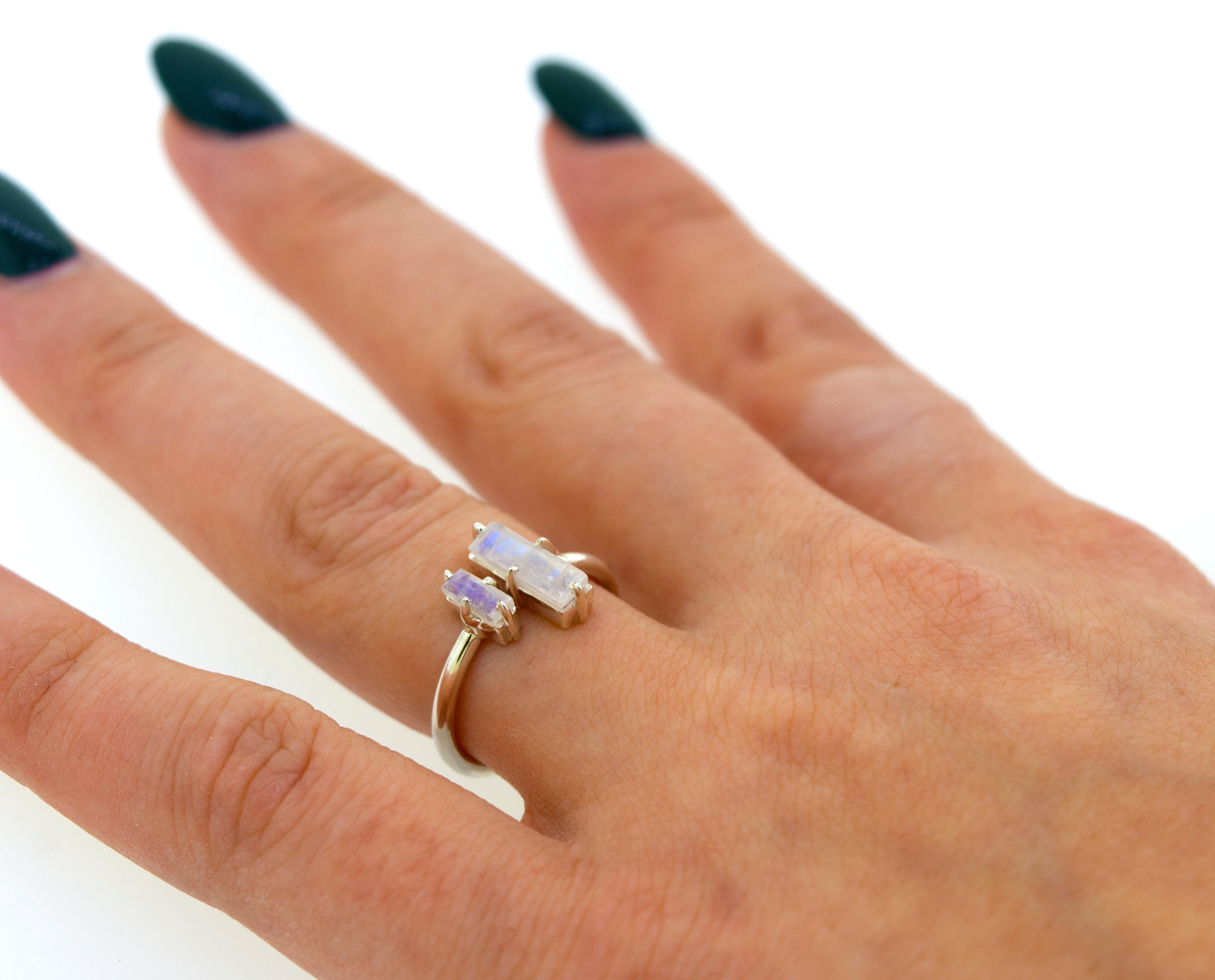Close-up of a woman's hand displaying a Online Only Exclusive Adjustable Crystal Ring with a large, aurora crystal centerpiece on a simple band, against a white background.