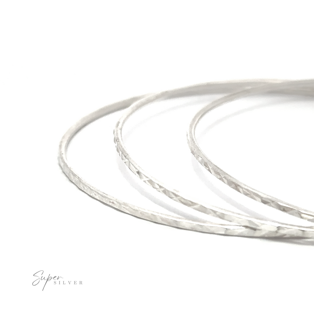Three Sparkling Faceted Bangle Bracelets with a minimal vibe on a white surface.