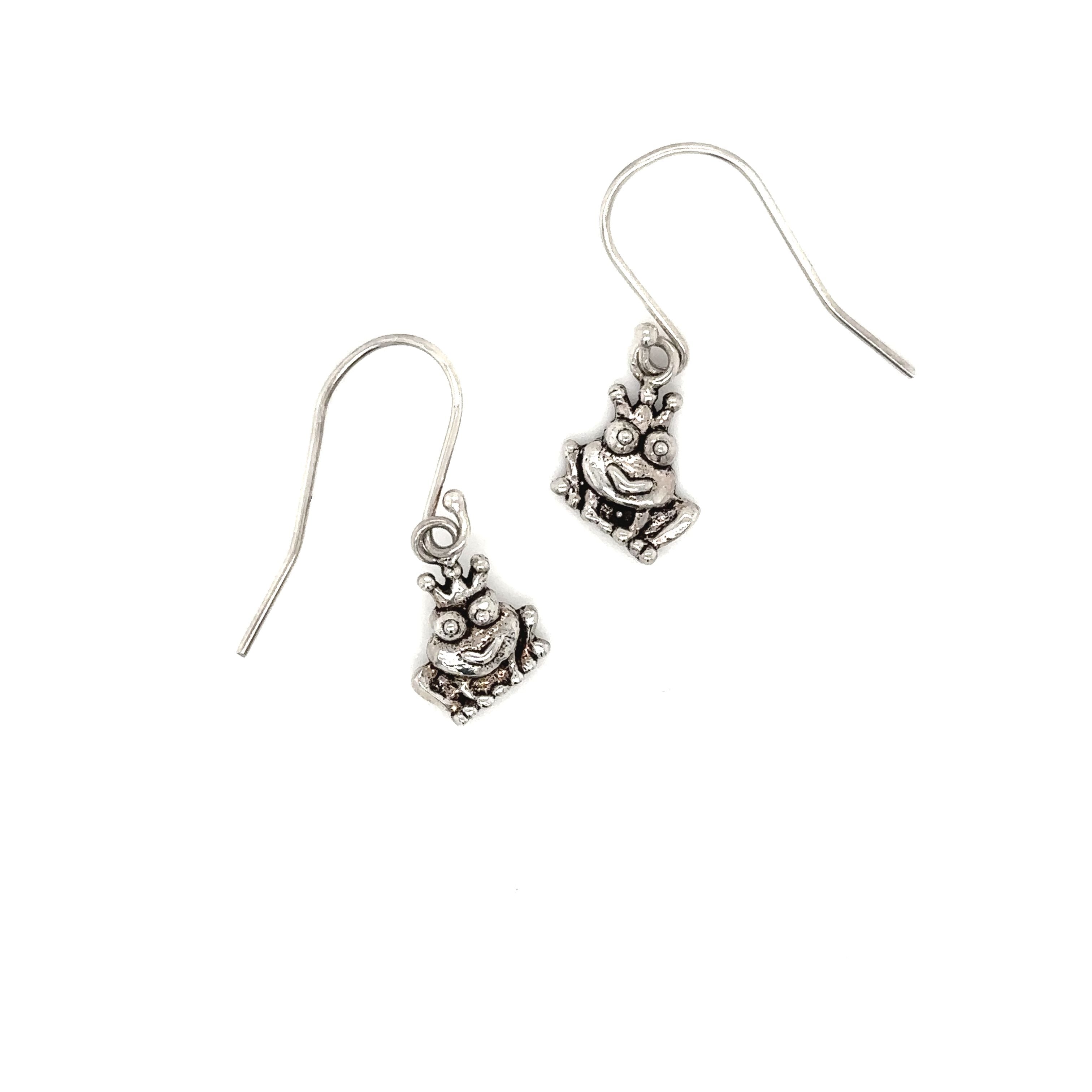 A pair of elegant Super Silver Frog Queen Earrings with a teddy bear on them.