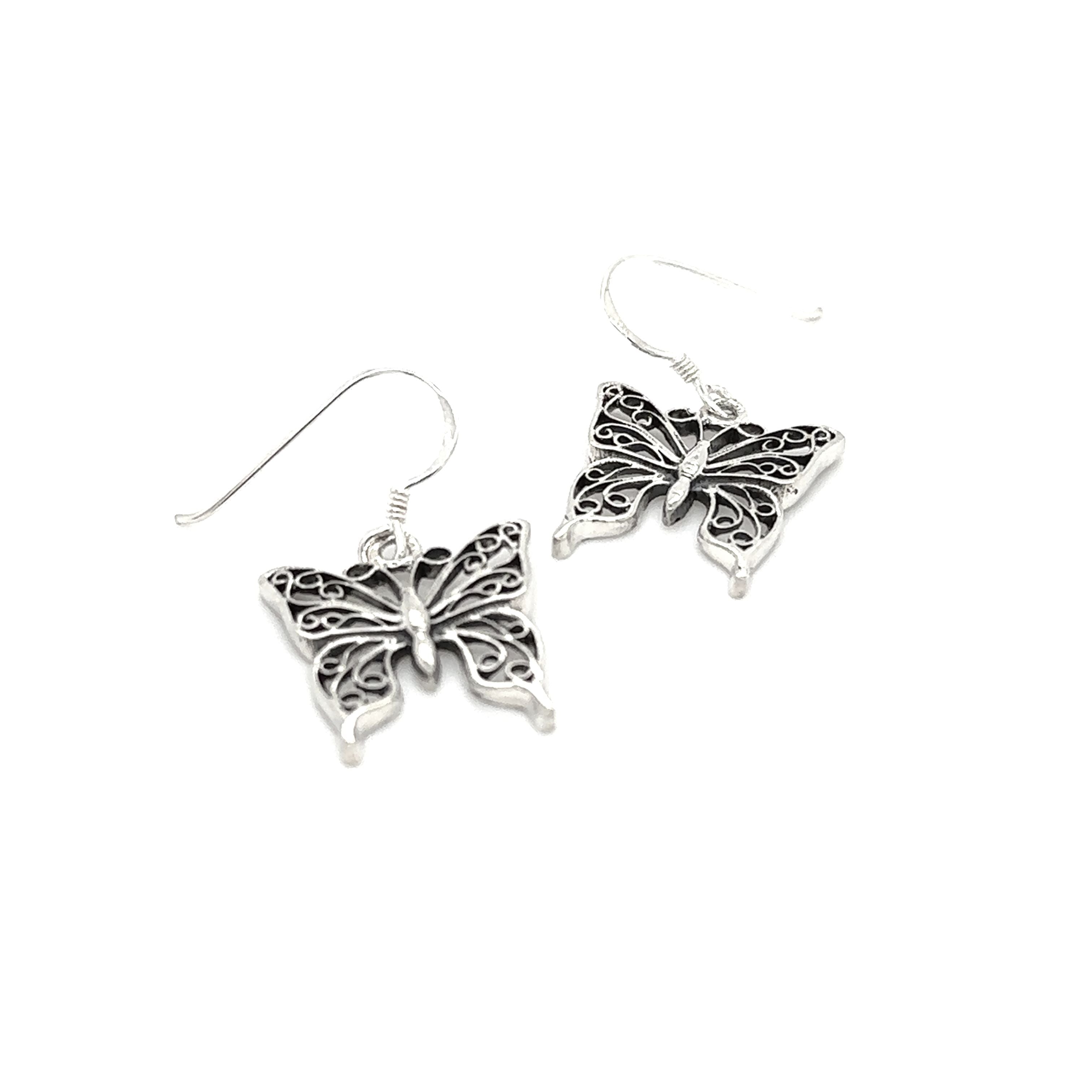 A pair of Super Silver filigree butterfly earrings with sterling silver wings on a white background.