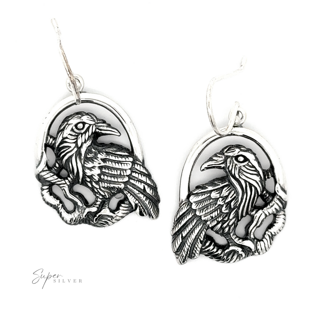 Two Detailed Raven Earrings displayed against a white background, each featuring intricate feather detailing.
