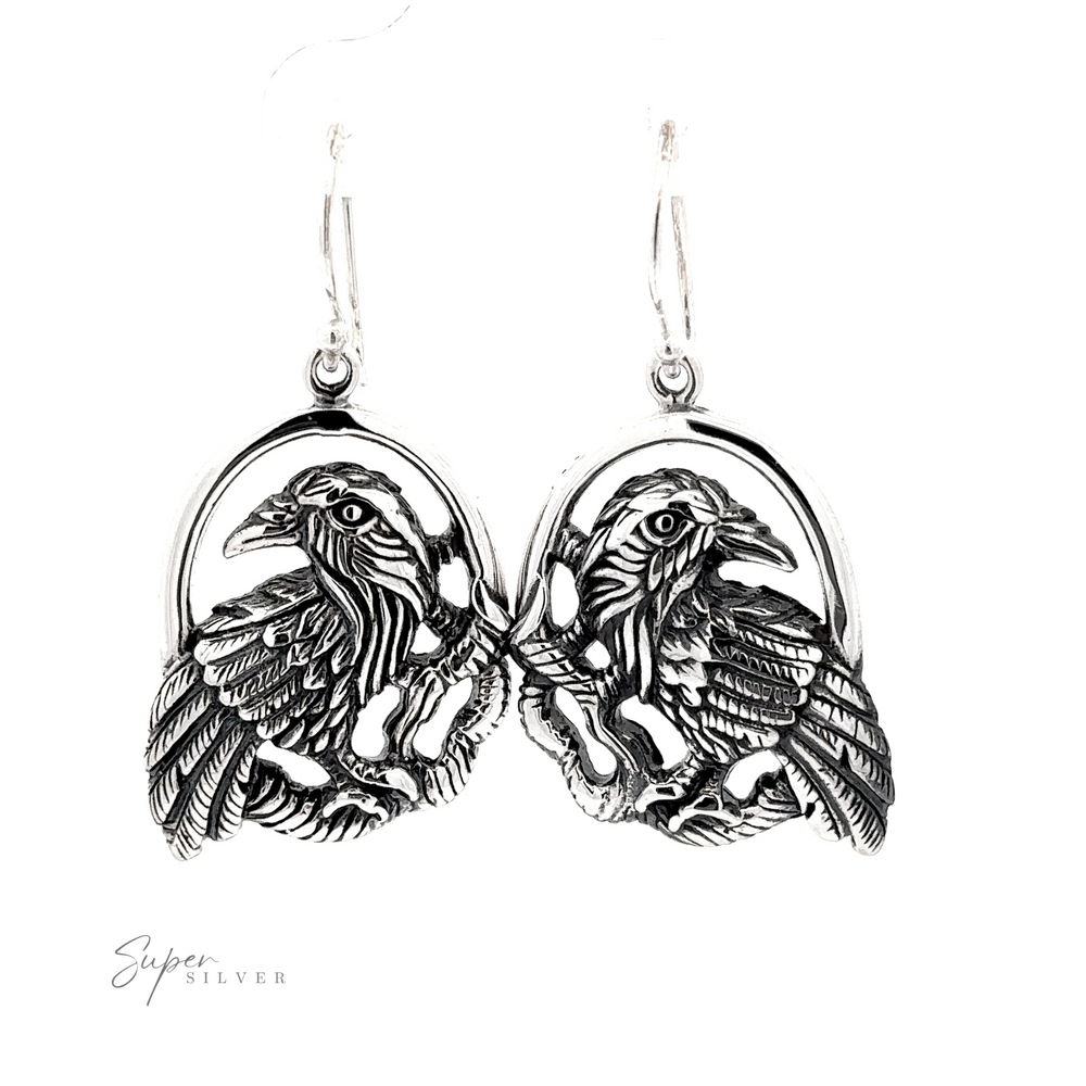 
                  
                    Detailed Raven Earrings featuring a symmetrical design of two ravens with wings spread, hanging from hooks.
                  
                