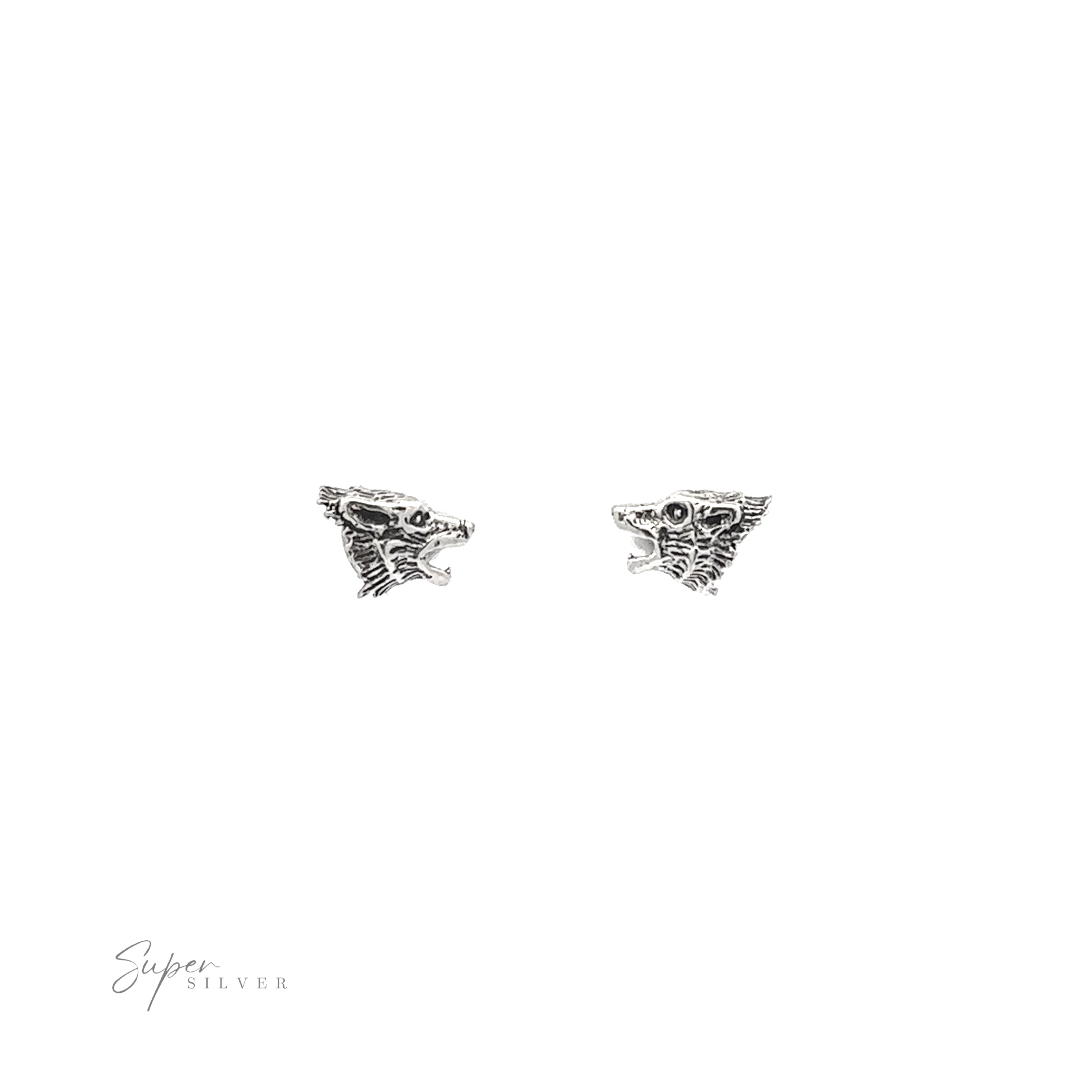 A pair of Wolf Head Studs on a white background.