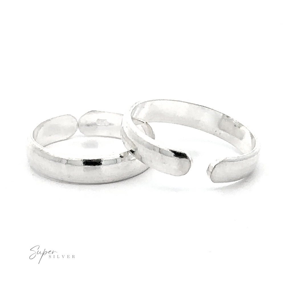 Two Rounded Plain Band Adjustable Toe Rings positioned on a white background, with a subtle reflection and signature in the corner.
