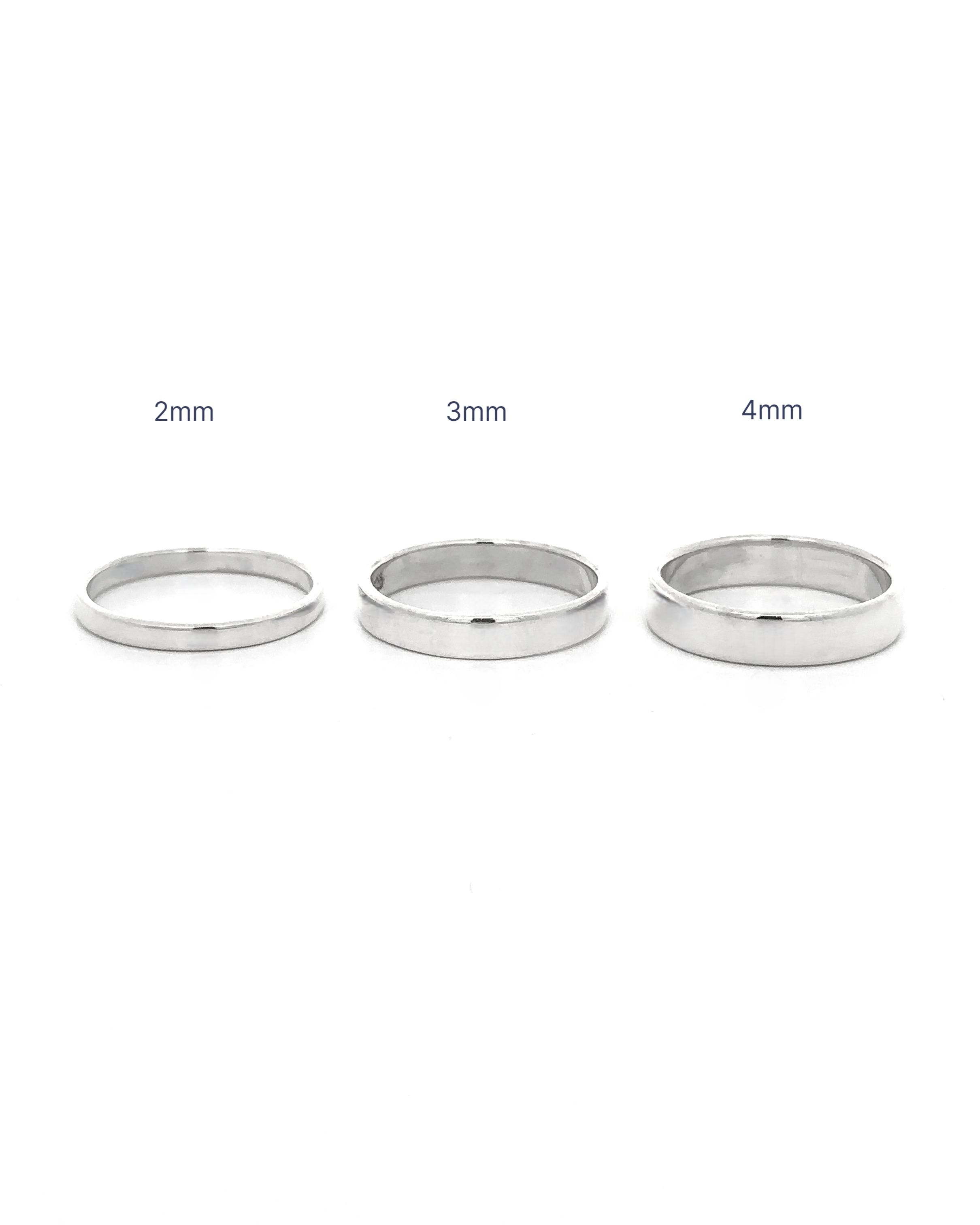 Three Minimalist Flat Band Rings in sterling silver are displayed side by side on a plain white background, labeled by width—2mm, 3mm, and 4mm from left to right—a perfect minimalist accessory.