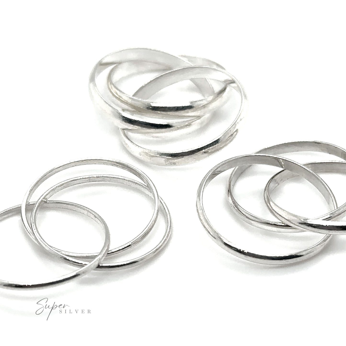 A trio of Three Ring Rolling Bands on a white surface, each displaying powerful symbolism.