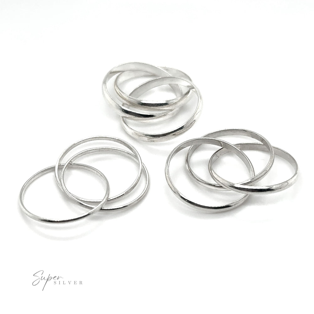 
                  
                    Three Ring Rolling Bands rest on a pristine white surface, evoking feelings of devotion.
                  
                