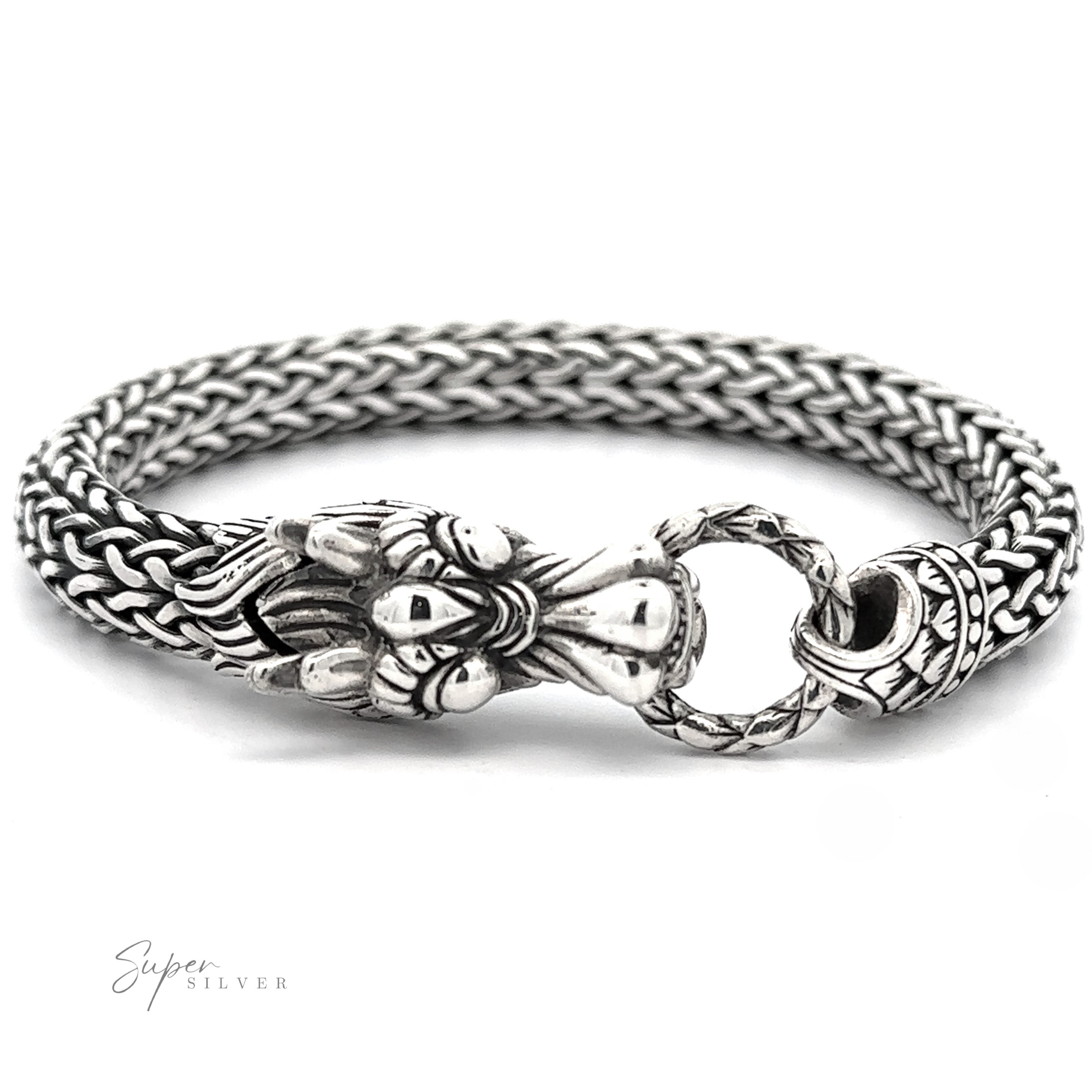 Sterling Silver Braided Rope Bracelet with Dragon Head with an intricate woven chain design and ornate clasp featuring bold dragon-like details. The sterling silver clasp ring connects to a decorative end piece, making a bold statement. Branding at bottom left corner.