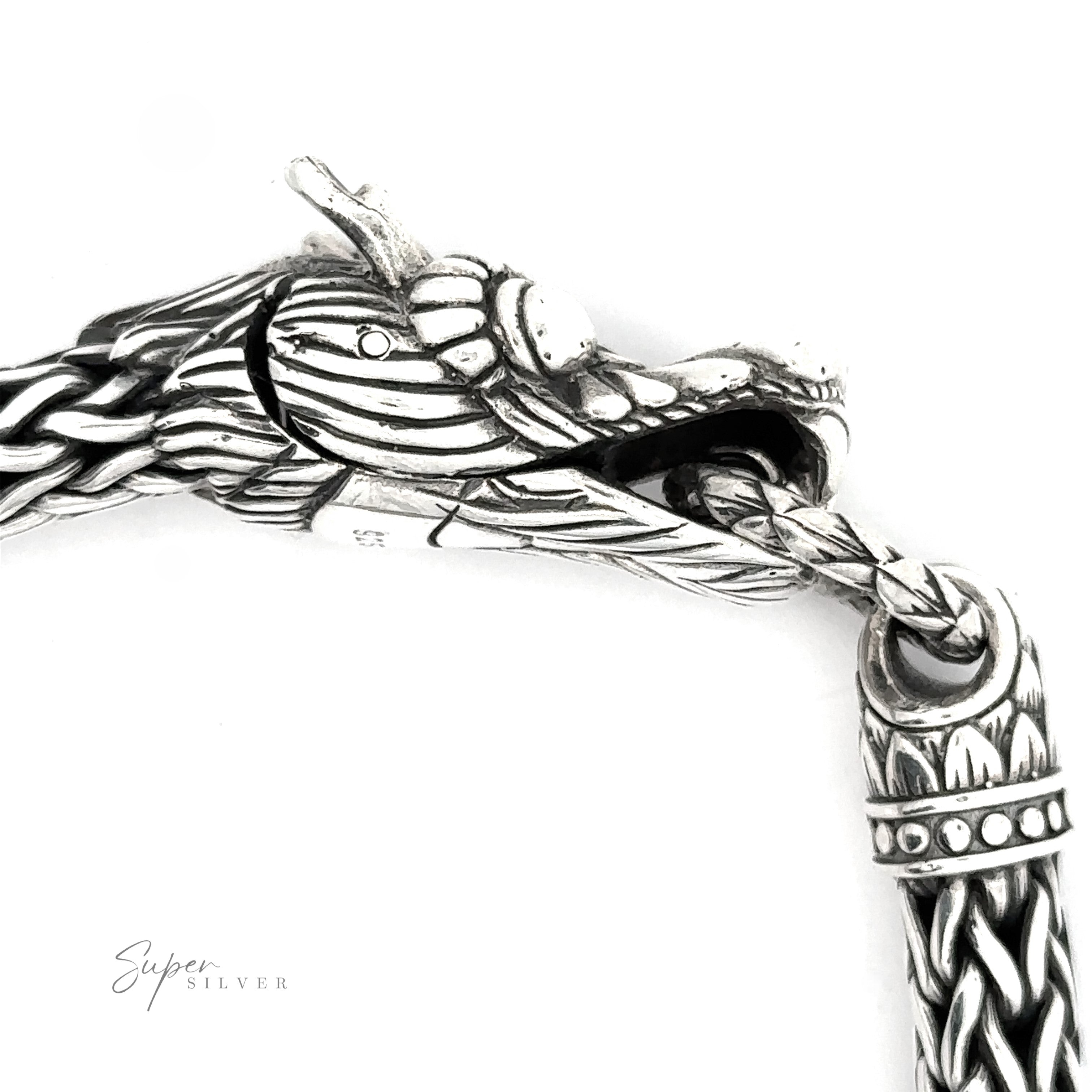 A detailed close-up of a Sterling Silver Braided Rope Bracelet with Dragon Head. The dragon's mouth is open, holding a ring attached to another part of the heavy-duty bracelet.