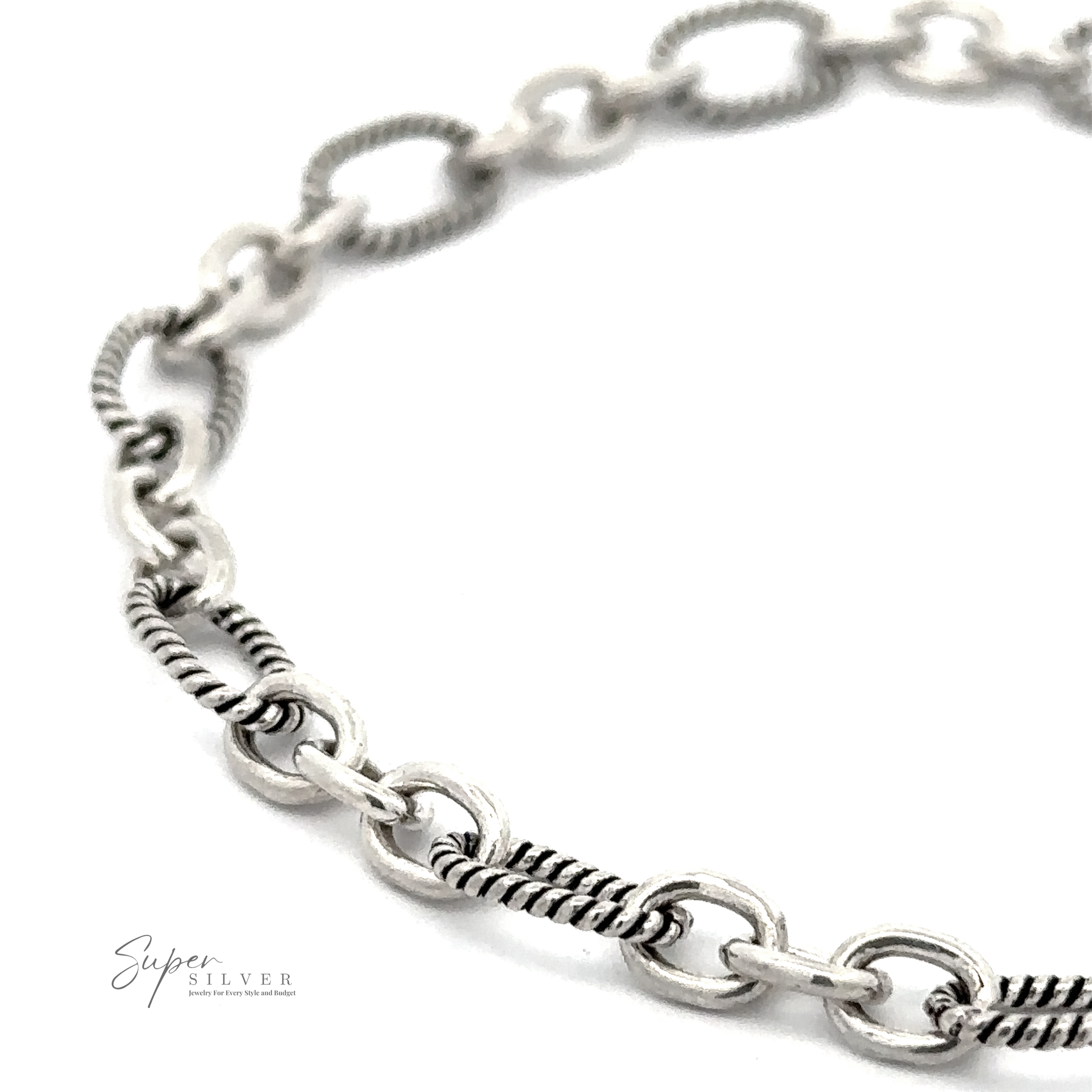 Close-up image of a silver chain bracelet with alternating solid and textured links on a white background. The logo "Super Silver" appears in the bottom left corner, highlighting this Lasso and Rolo Bracelet inspired by Balinese artistry.