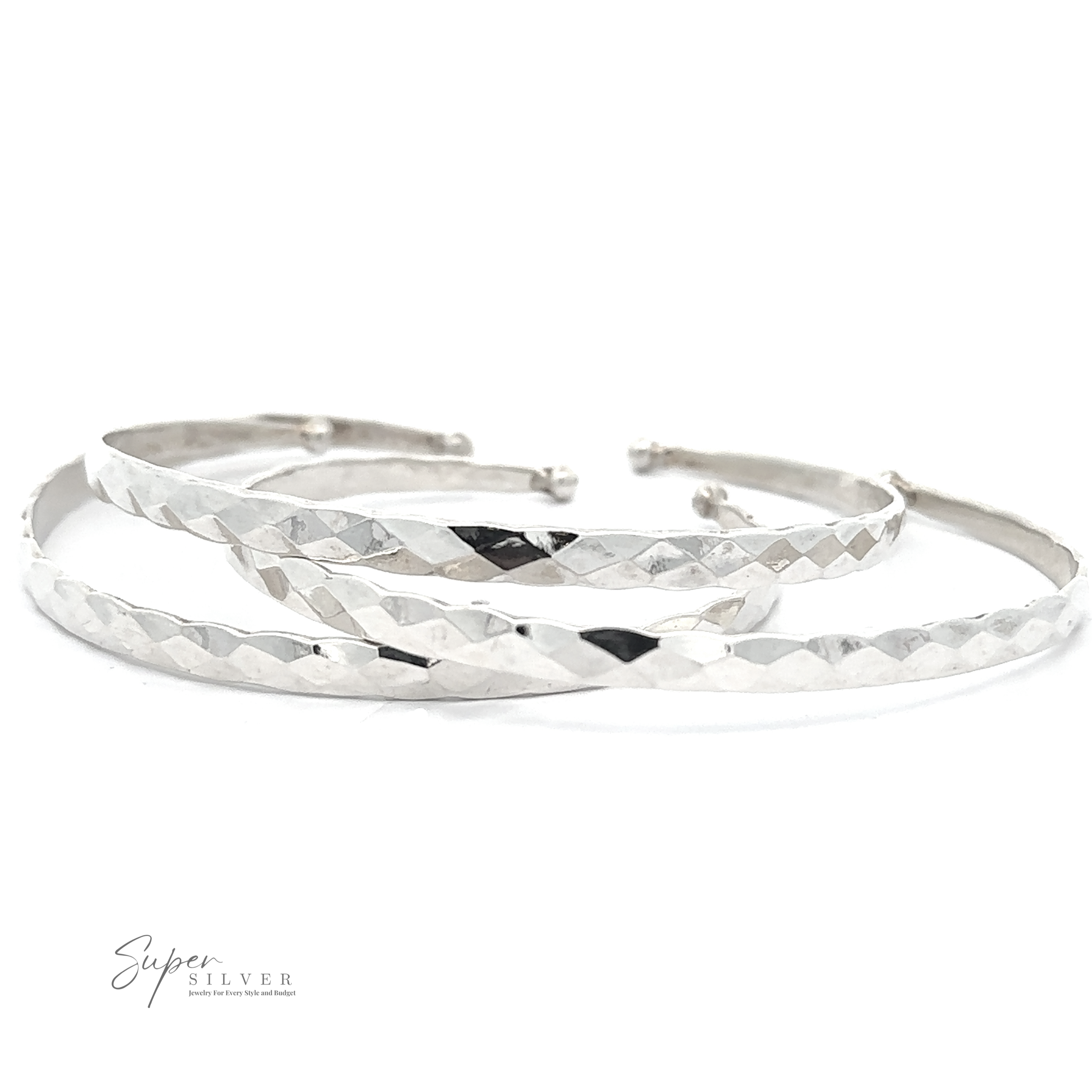 A set of three thin, textured silver bangles, crafted from .925 Sterling Silver, placed on a white surface. The Stackable Hammered Cuff boasts a geometric pattern, adding a sophisticated touch. The lower left corner shows the text "Super Silver".