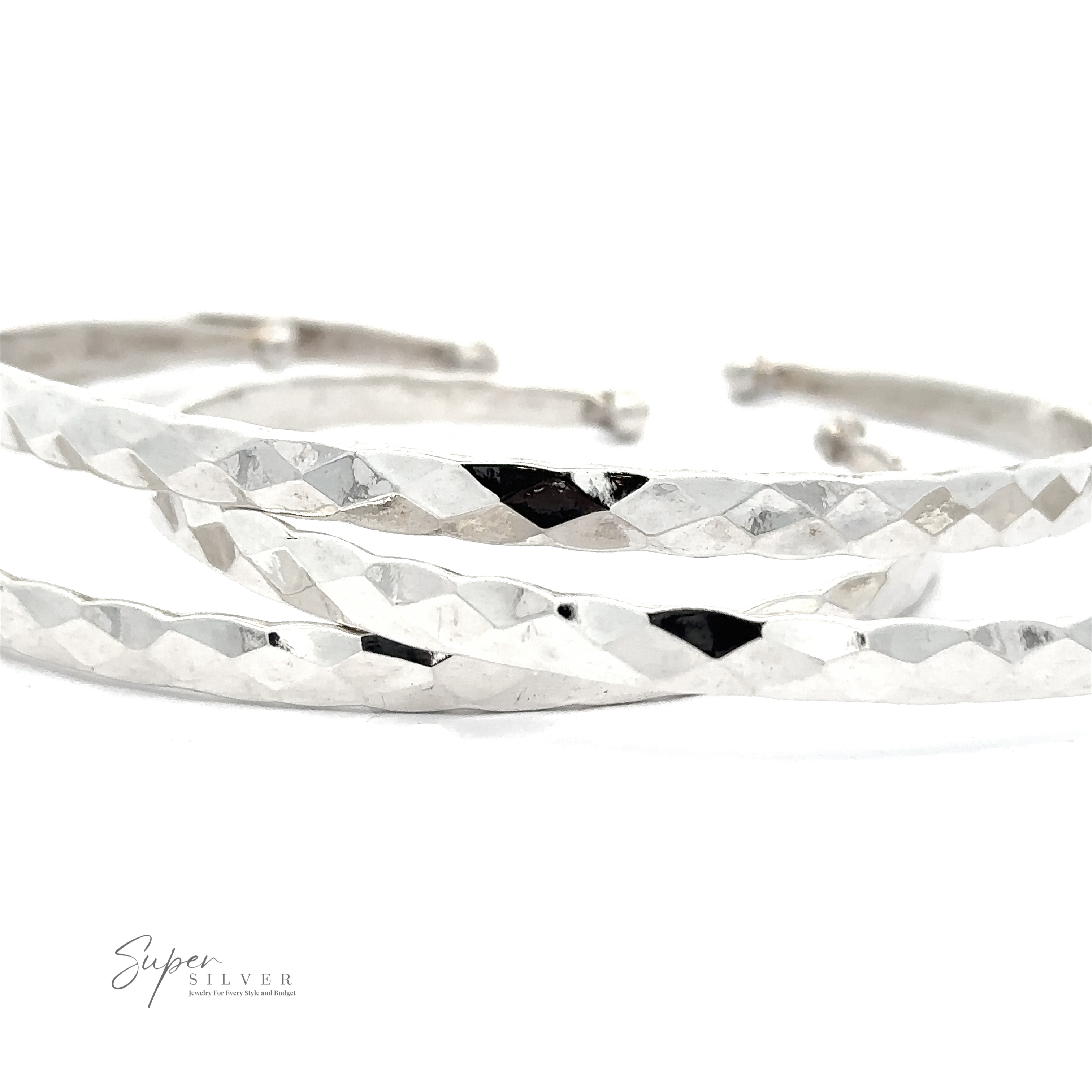 A close-up photo of two Stackable Hammered Cuffs, exuding a timeless look, placed parallel to each other on a white background. The brand "Super Silver" is visible in the bottom left corner.