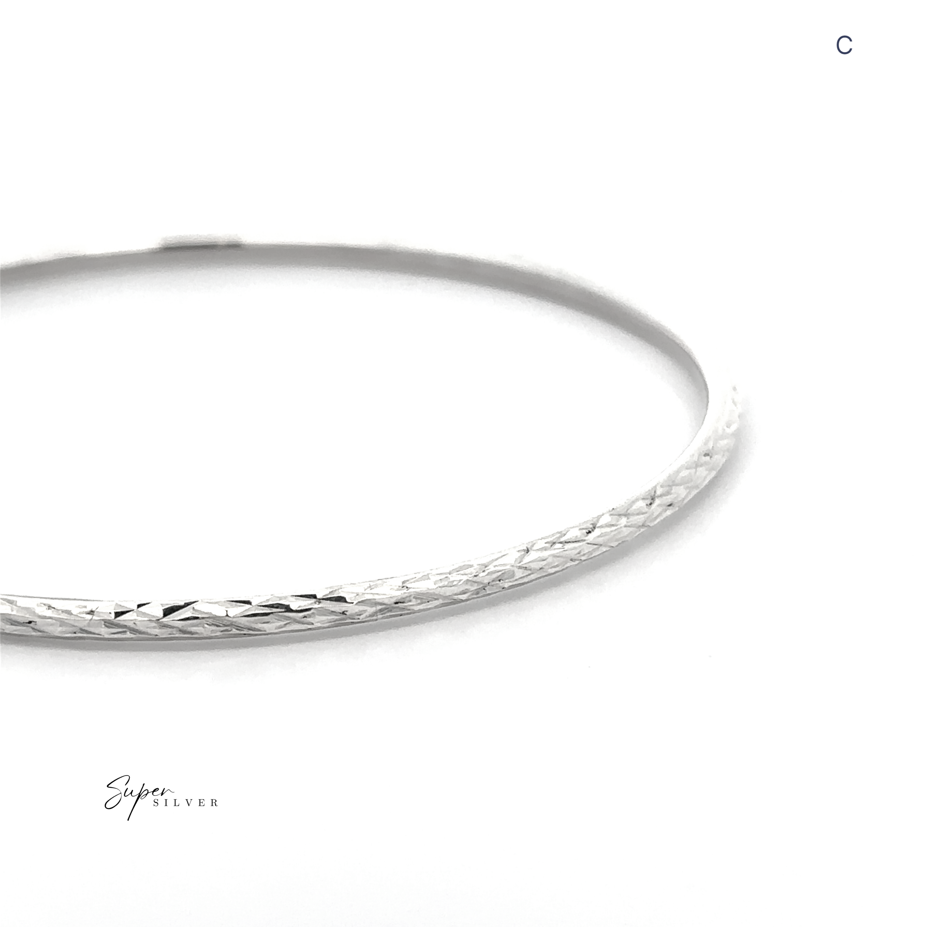 The Spark Stack Bangles, slim and textured in sterling silver, are shown on a white background with "Super Silver" and a "C" in the corner, standing out among elegant jewelry and faceted bangles.
