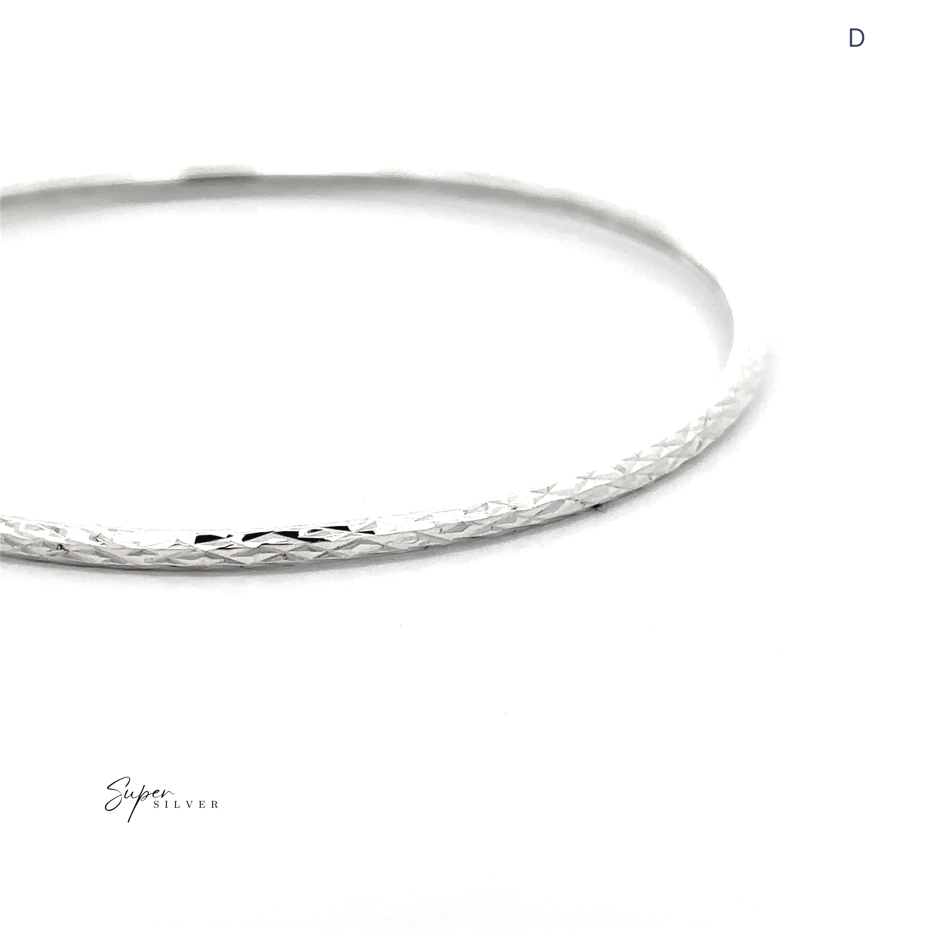 The Spark Stack Bangles—a simple, textured sterling silver bangle—shimmers on a white background, with the letter "D" in the top right corner.