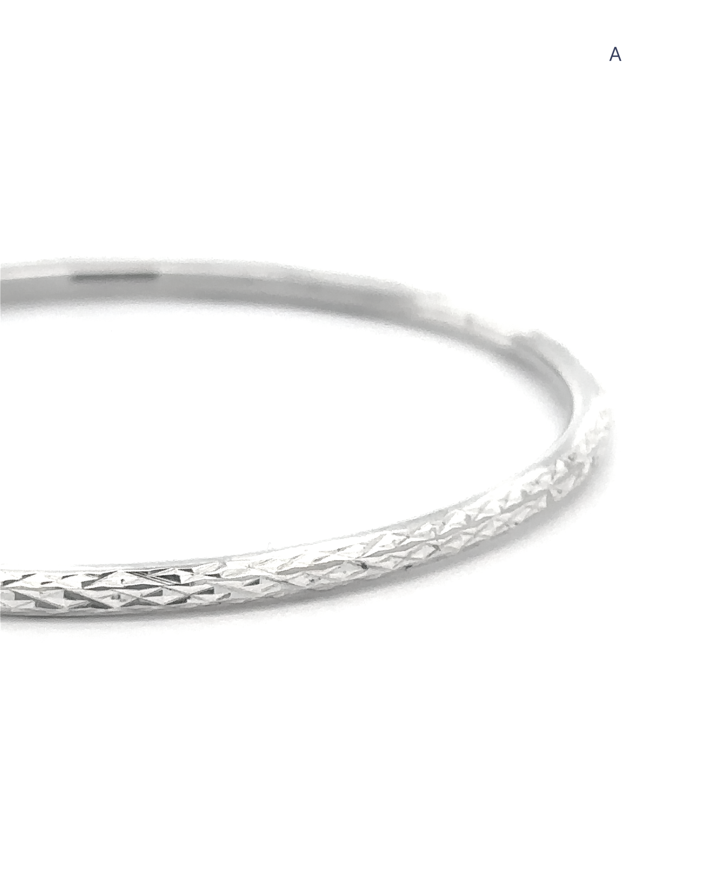 A close-up of The Spark Stack Bangles—thin, faceted sterling silver bangles with a diamond-cut texture—displayed against a white background, creating an elegant jewelry piece suitable for any occasion.