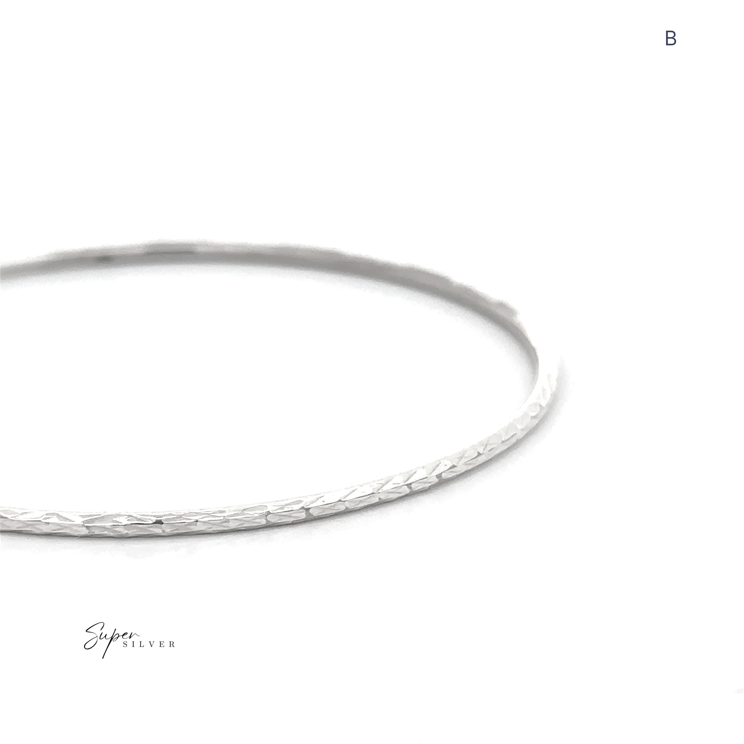 The Spark Stack Bangles: A thin, textured sterling silver bangle bracelet displayed on a white background with the letter "B" in the top right corner—ideal for those who love elegant jewelry.