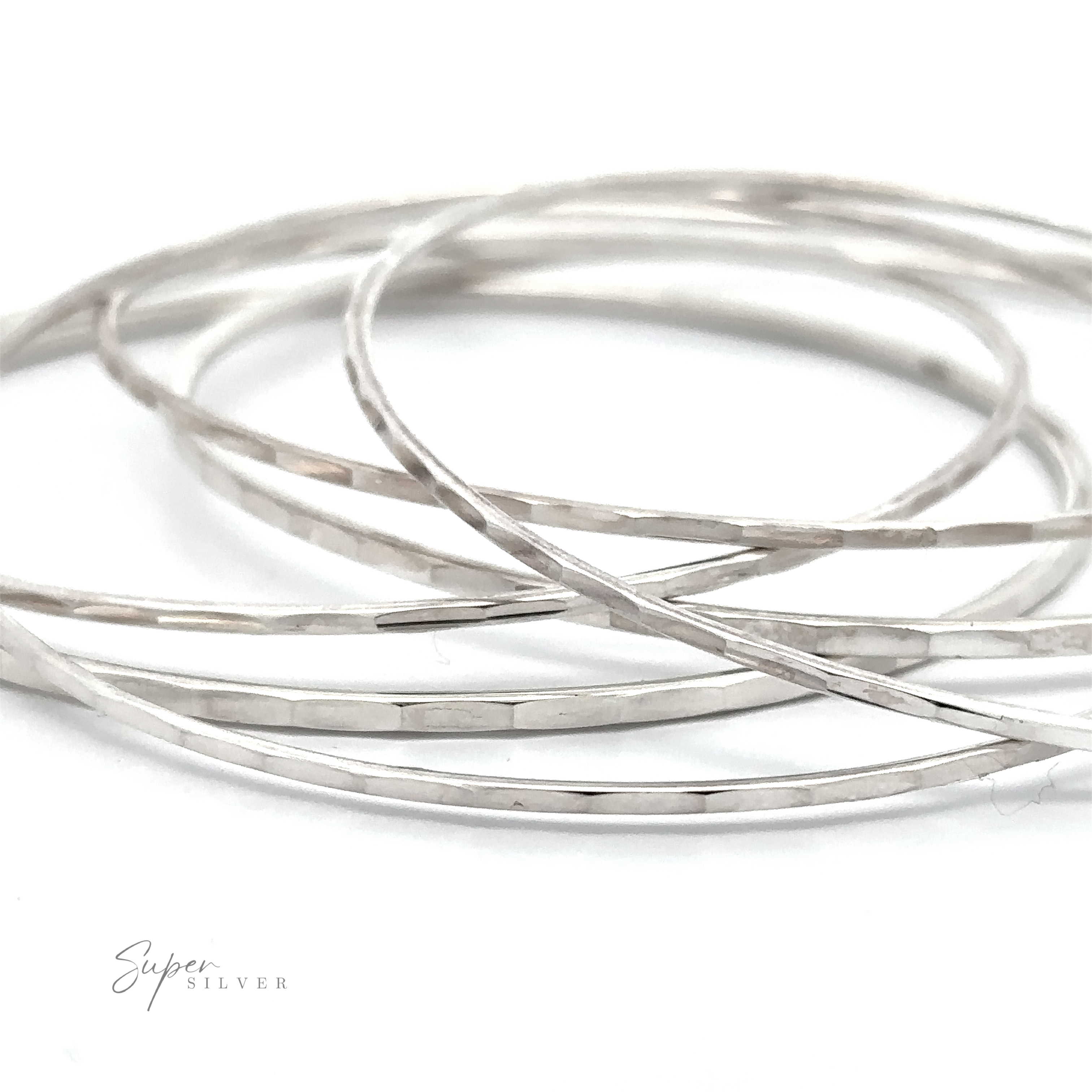 Multiple thin Faceted Silver Bangle Bracelets are intertwined and laid out against a white background, with the words "Super Silver" visible in the bottom left corner.