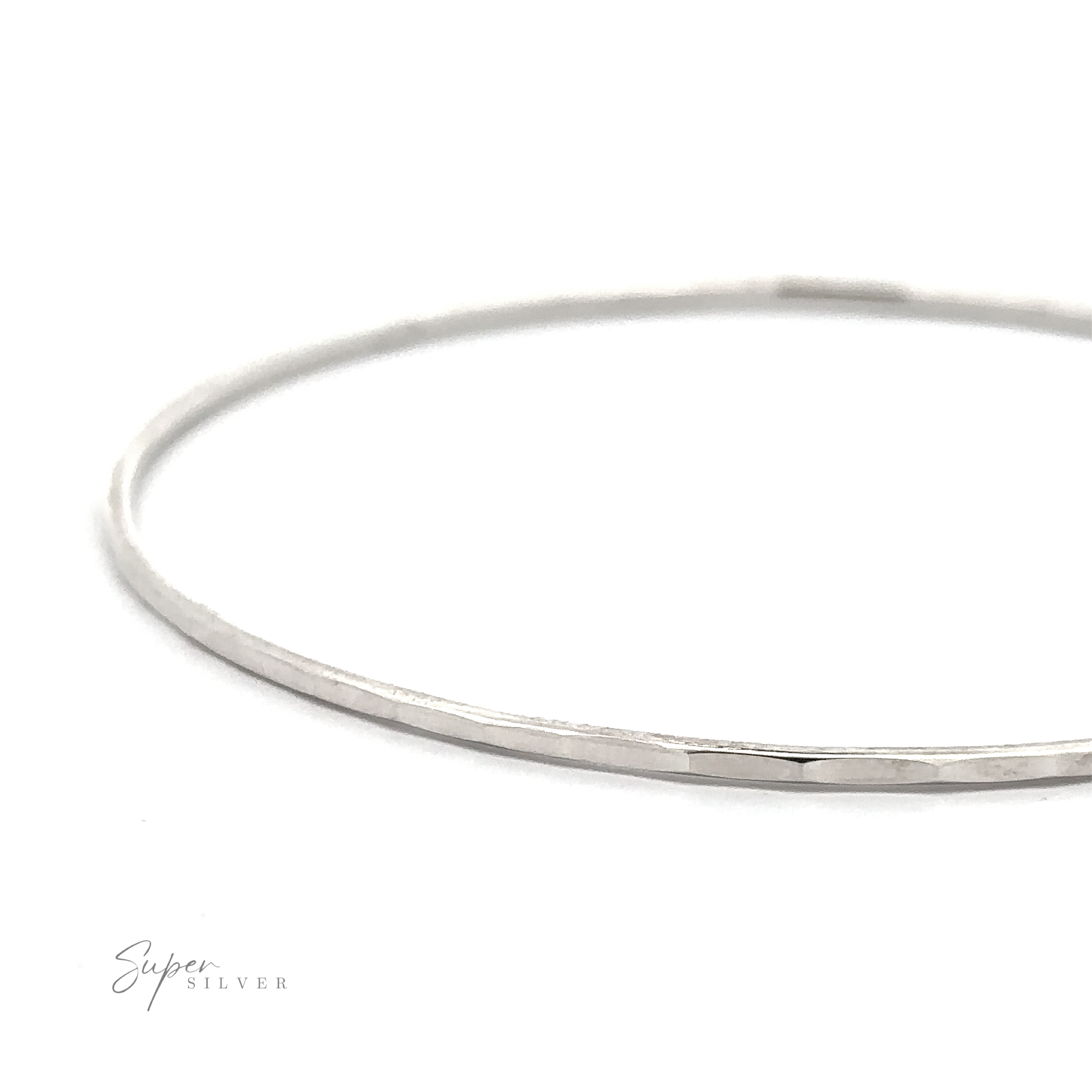 A simple, thin, Faceted Silver Bangle Bracelet with a slightly hammered texture is shown against a white background. The words "Super Silver" are visible in the bottom left corner. This piece of minimalist jewelry adds an elegant touch to any ensemble.