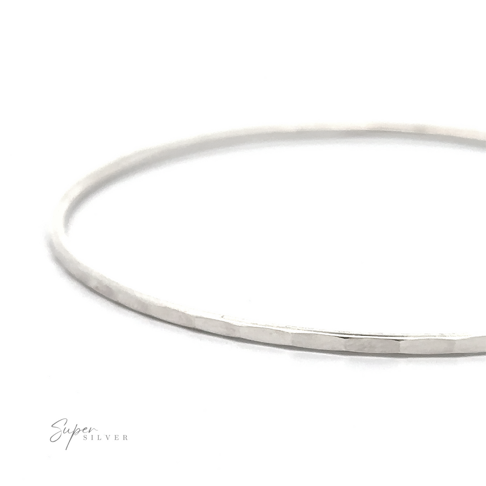 
                  
                    A thin, round Faceted Silver Bangle Bracelet with a smooth finish, shown against a white background. The words "Super Silver" are visible in the bottom left corner.
                  
                