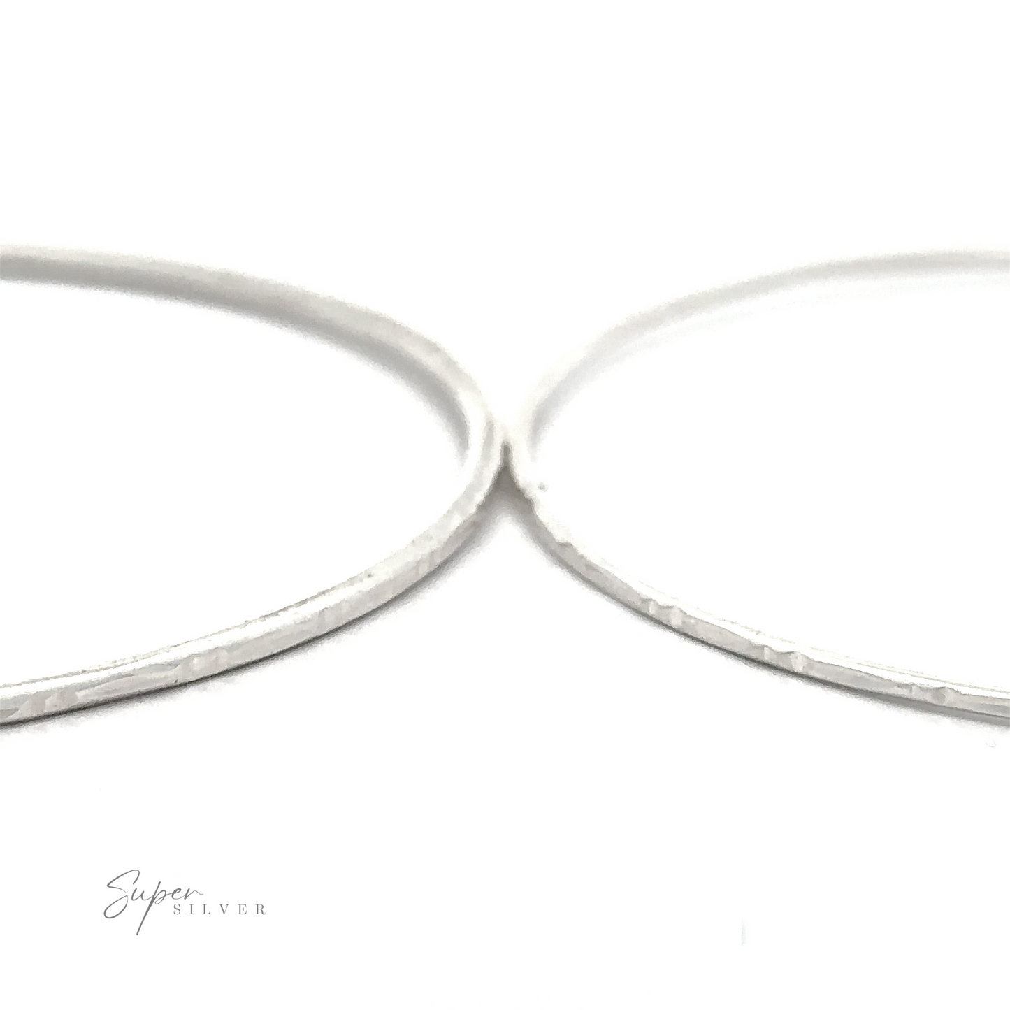 
                  
                    Close-up of two thin, Sparkling Faceted Bangle Bracelets with a textured surface. The background is white, and the text "Super Silver" appears in the lower left corner.
                  
                