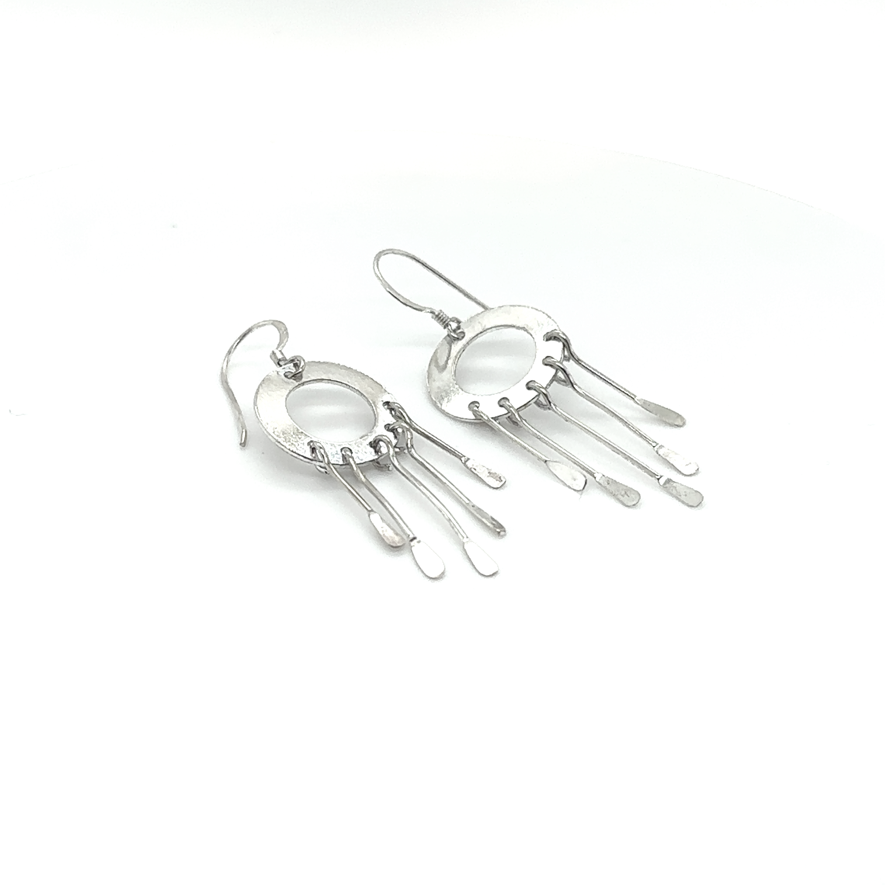 A pair of Super Silver Circle Tassel Earrings on a white background.