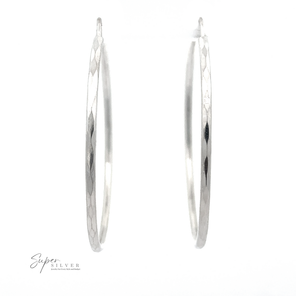 A pair of 1.5mm Faceted Silver Infinity Hoops with a hammered texture, displayed on a white background with the logo "super silver" at the bottom left, now featuring a rhodium finish.